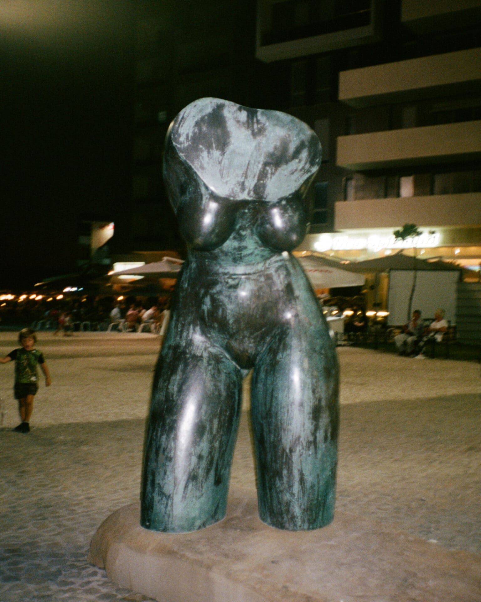 Hazel Gaskin photographs Albania | A metal statue of a woman's body in a square at night