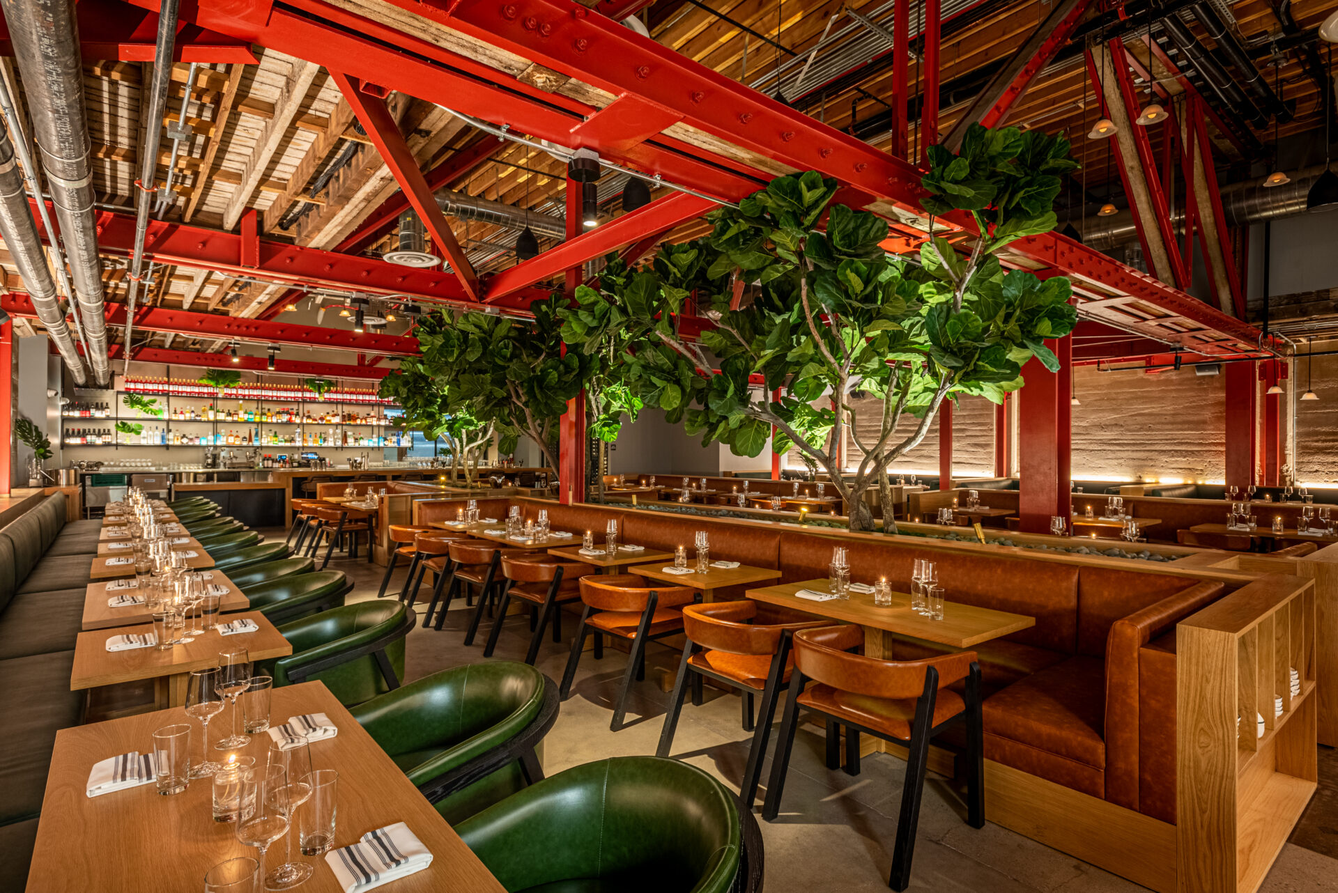 LA's best restaurants | The dining room at Grand Master Recorders, with a red steel framed ceiling, large indoor trees, and rows of square tables with arm chairs