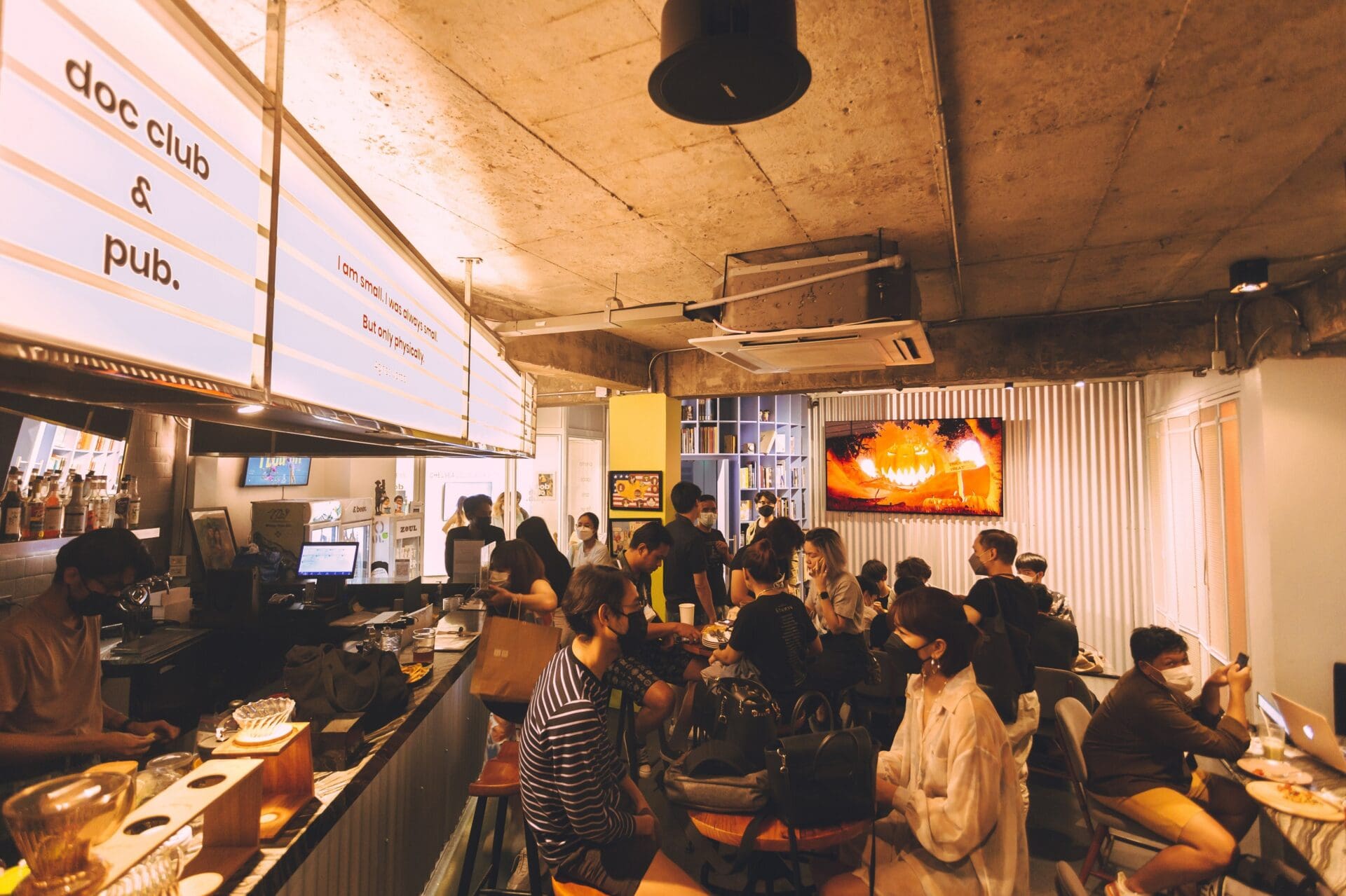 Best museums and galleries in Bangkok | a view of a busy bar scene with the words doc bar and club written on a light box sign above the bar.