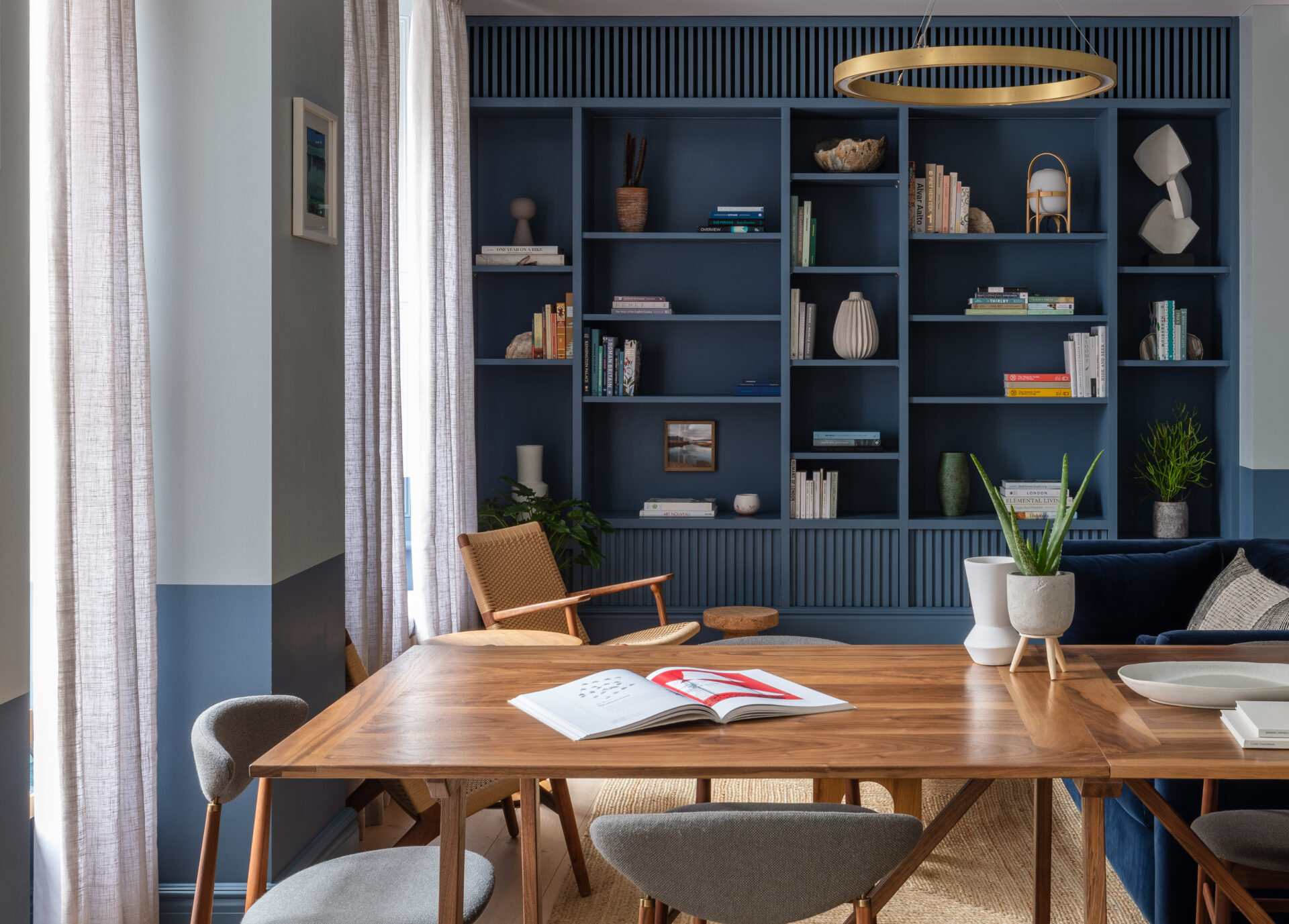 Where to stay in London | a wooden table in front of a dark blue bookcase at Inhabit Southwick Street