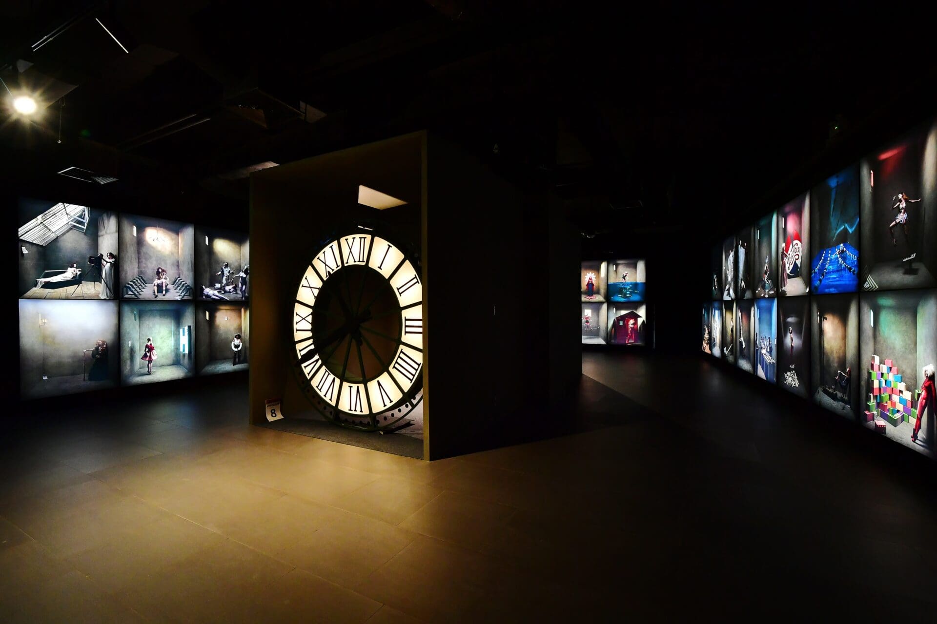 Best museums and galleries in Bangkok | A shadowy view of an art gallery inside River City Bangkok, with a luminous clock face installation in the centre of the room.