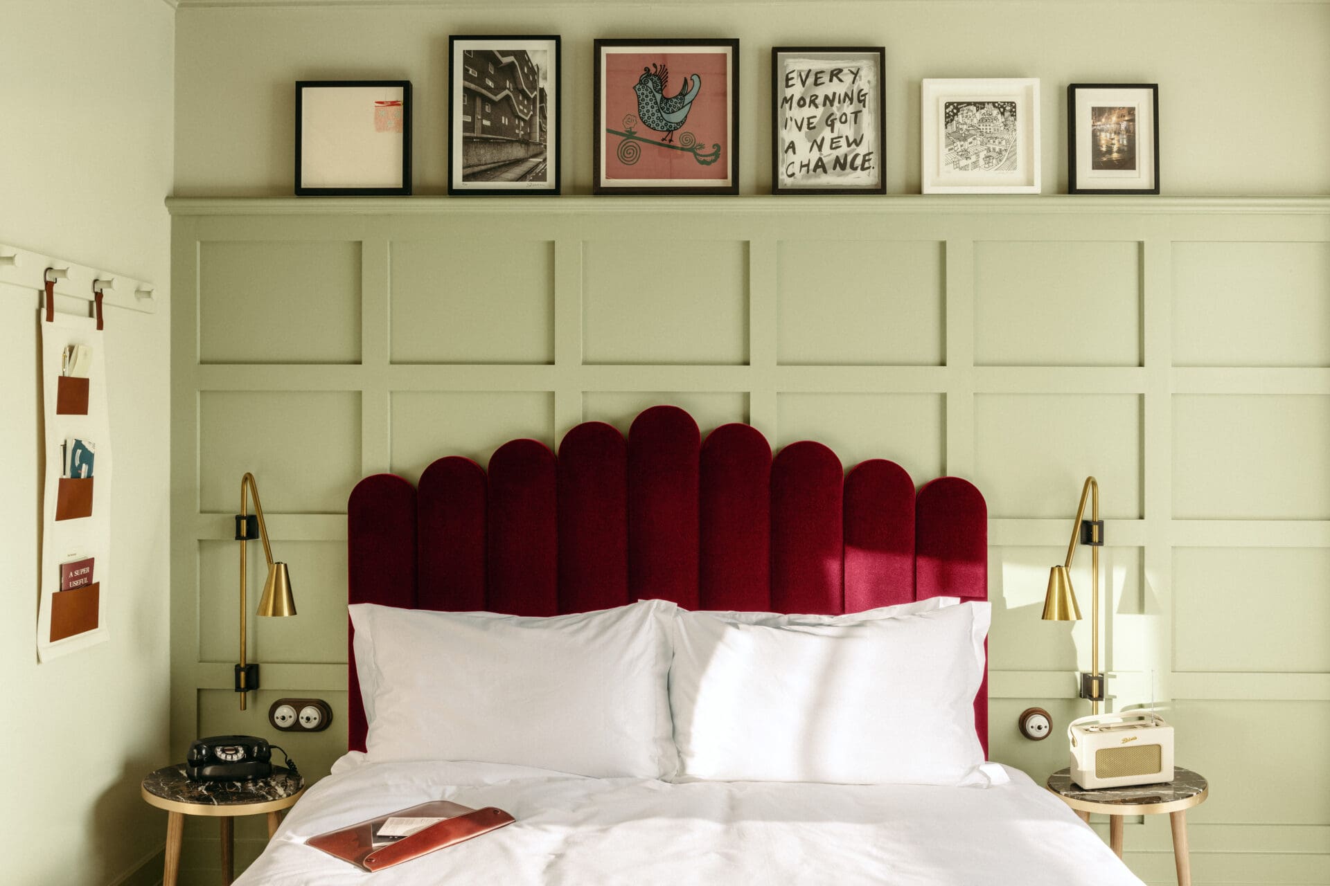 Where to stay in London: a white-sheeted bed with a ruby-red velvet headboard in front of a mint green wall at The Hoxton Southwark