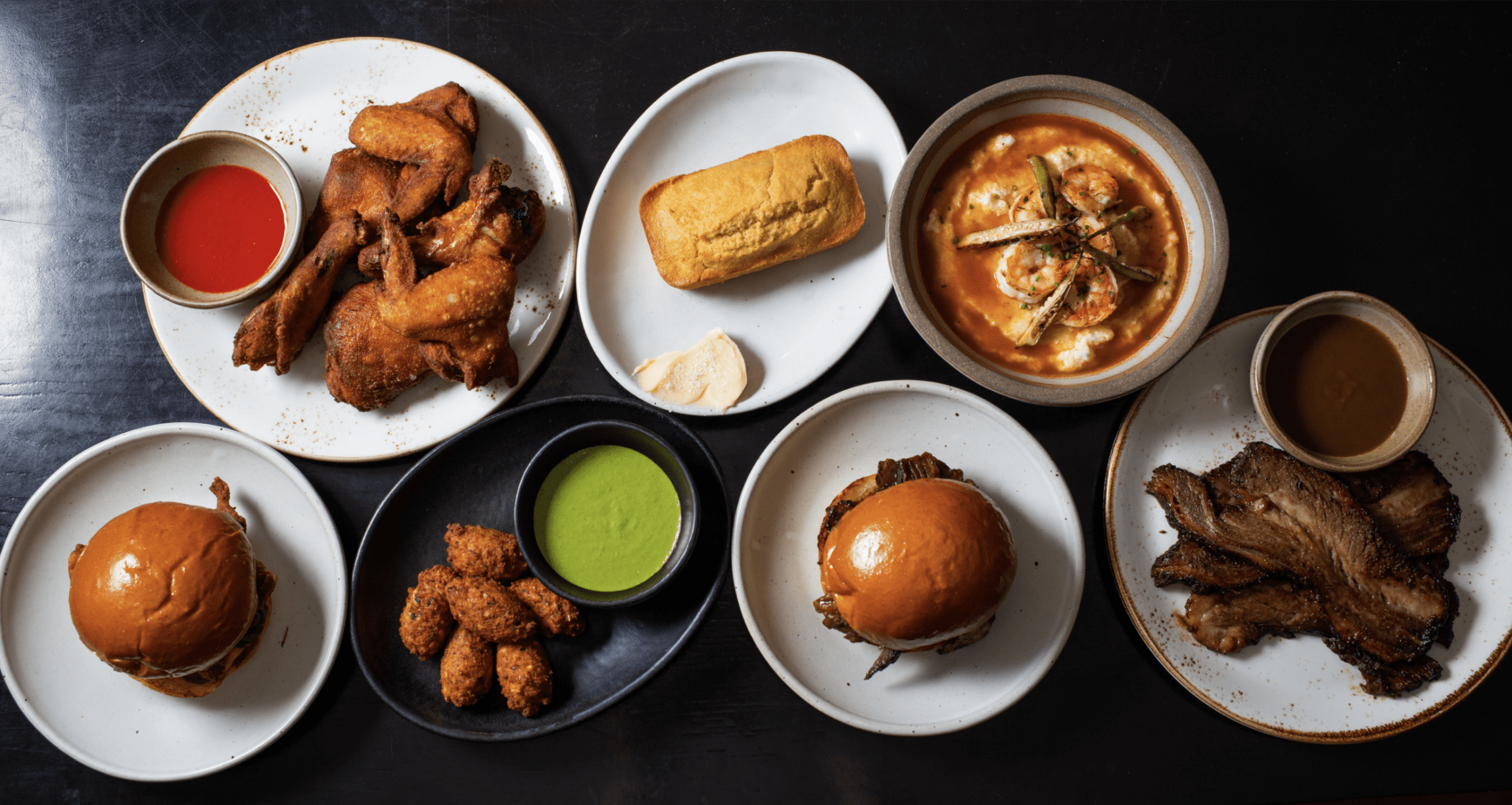 The best restaurants in LA | Various soul food dishes served on a black tabletop at Alta Adams