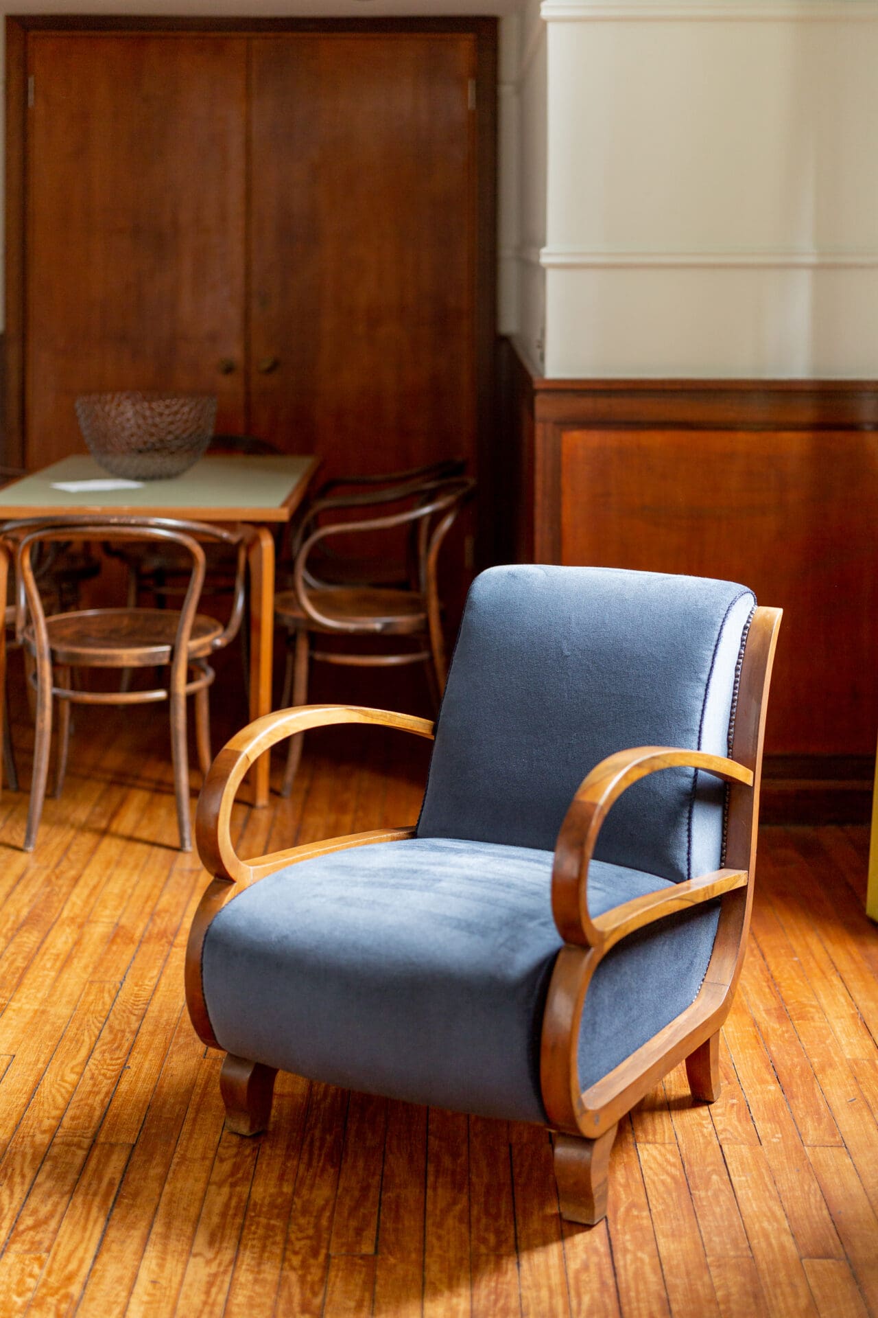 Best hotels London | A midcentury modern armchair with blue upholstery and wooden arms at the Town Hall Hotel in Bethnal green