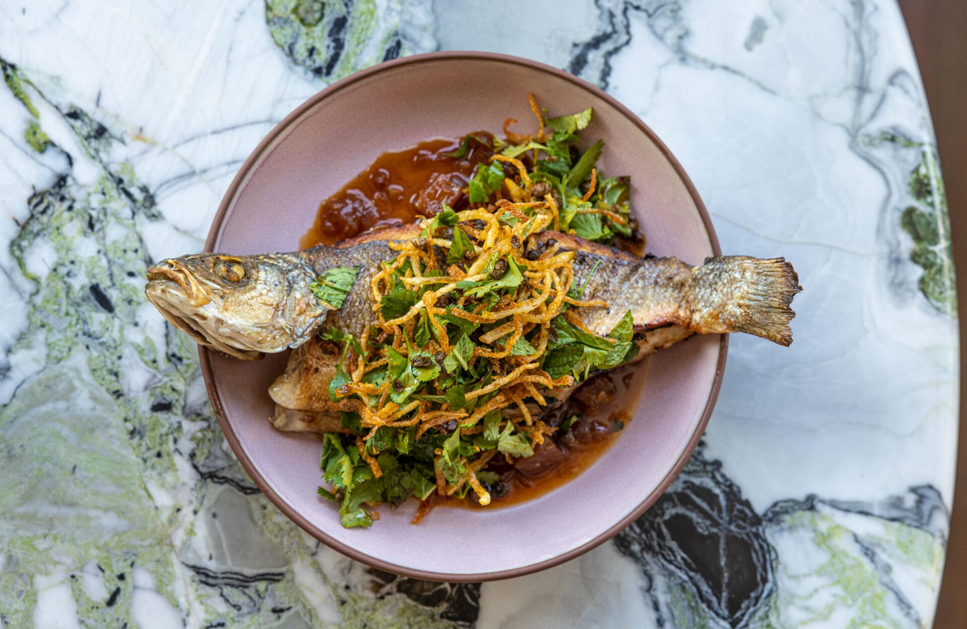Best LA restaurants | a crispy fried fish topped with onions at Cabra at The Hoxton in LA