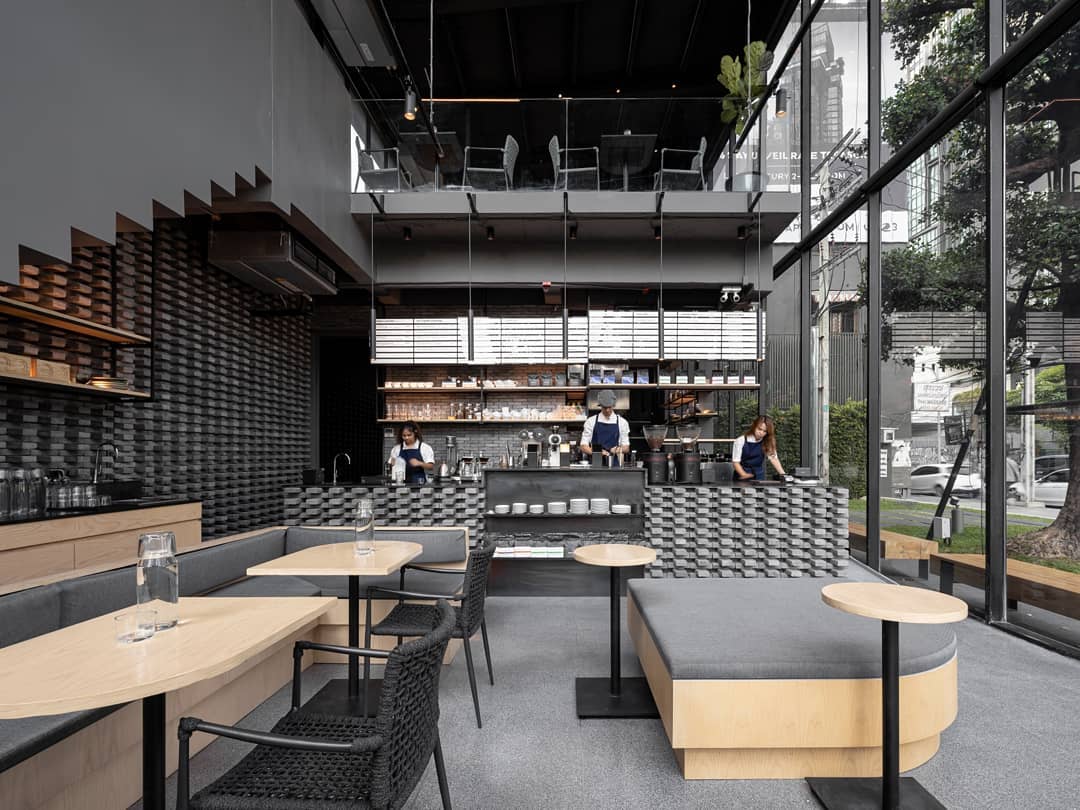 Where to co-work in Bangkok | Pale wooden tables and grey furnishings in coffee shop Kaizen