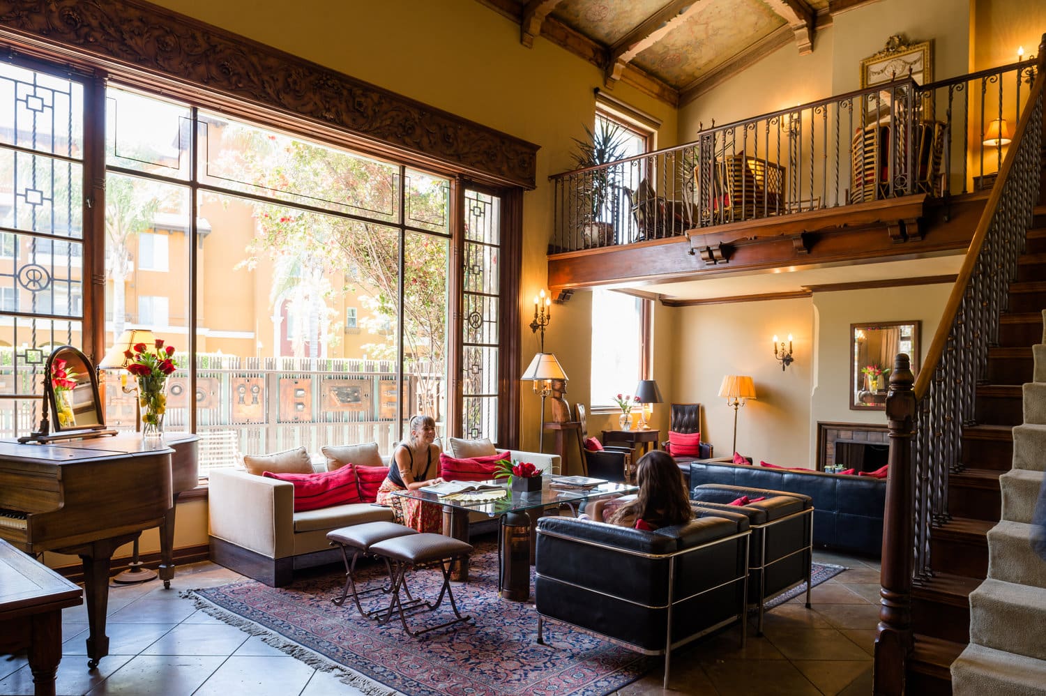 LA's best co-working spaces | A high-ceilinged room with a mezzanine and large windows, with vintage furniture including two leather sofas