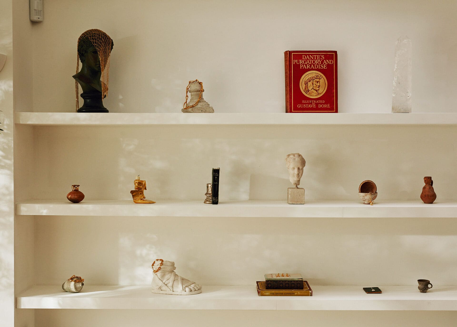 Rosh Mahtani, Alighieri | Some white shelves in Mahtani's studio, with objets, books and jewellery