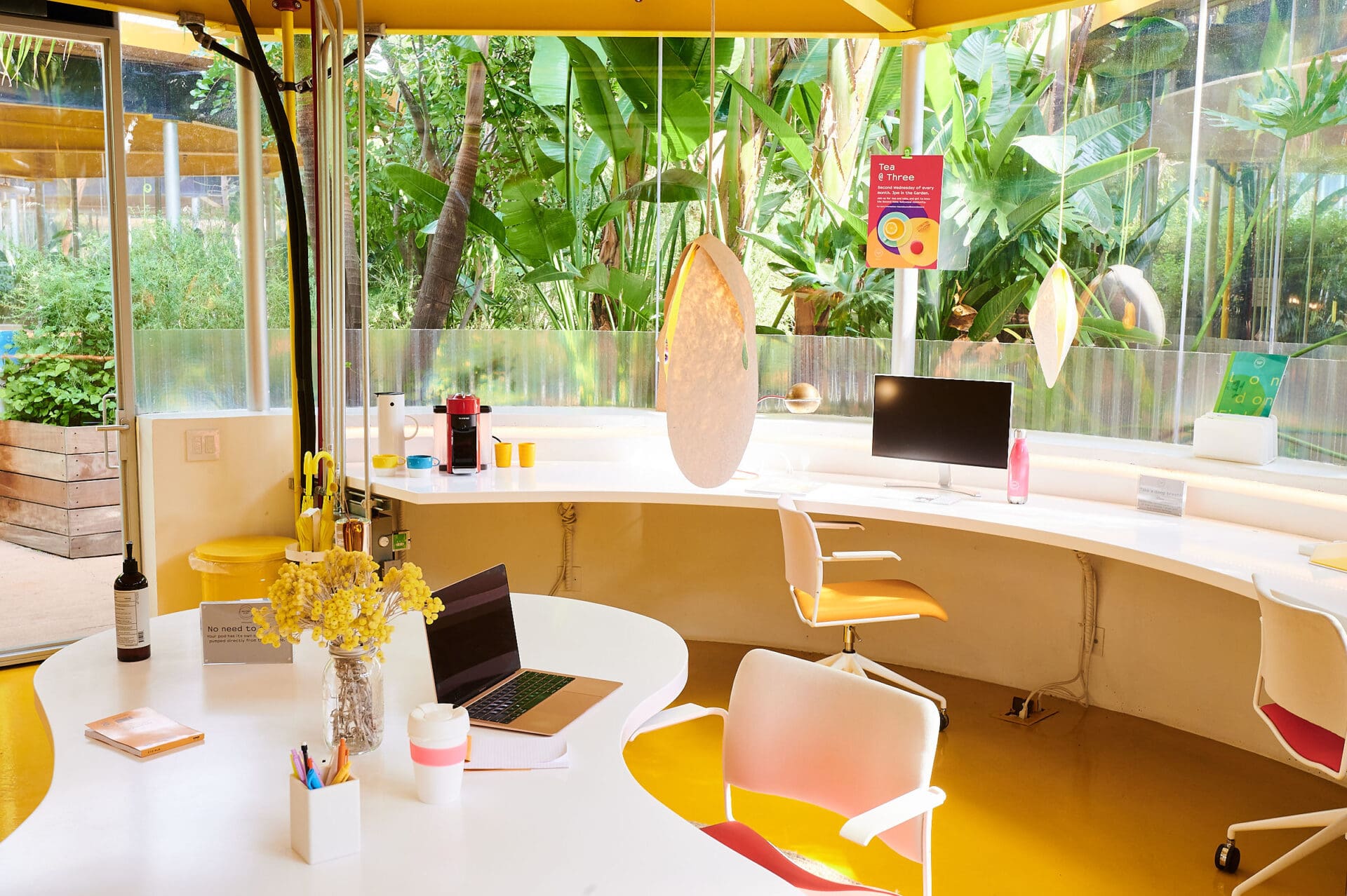 LA co-working spots | white desks and chairs above a bright yellow floor in a pod at Second Home LA, with windows looking out onto greenery