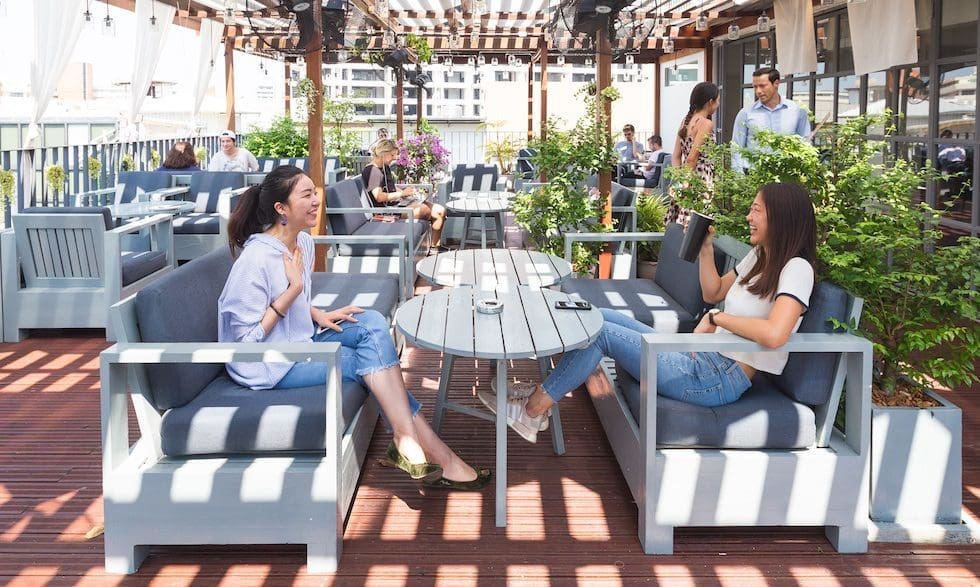 Where to co-work in Bangkok | two people sitting at an outdoor dining space at The Hive