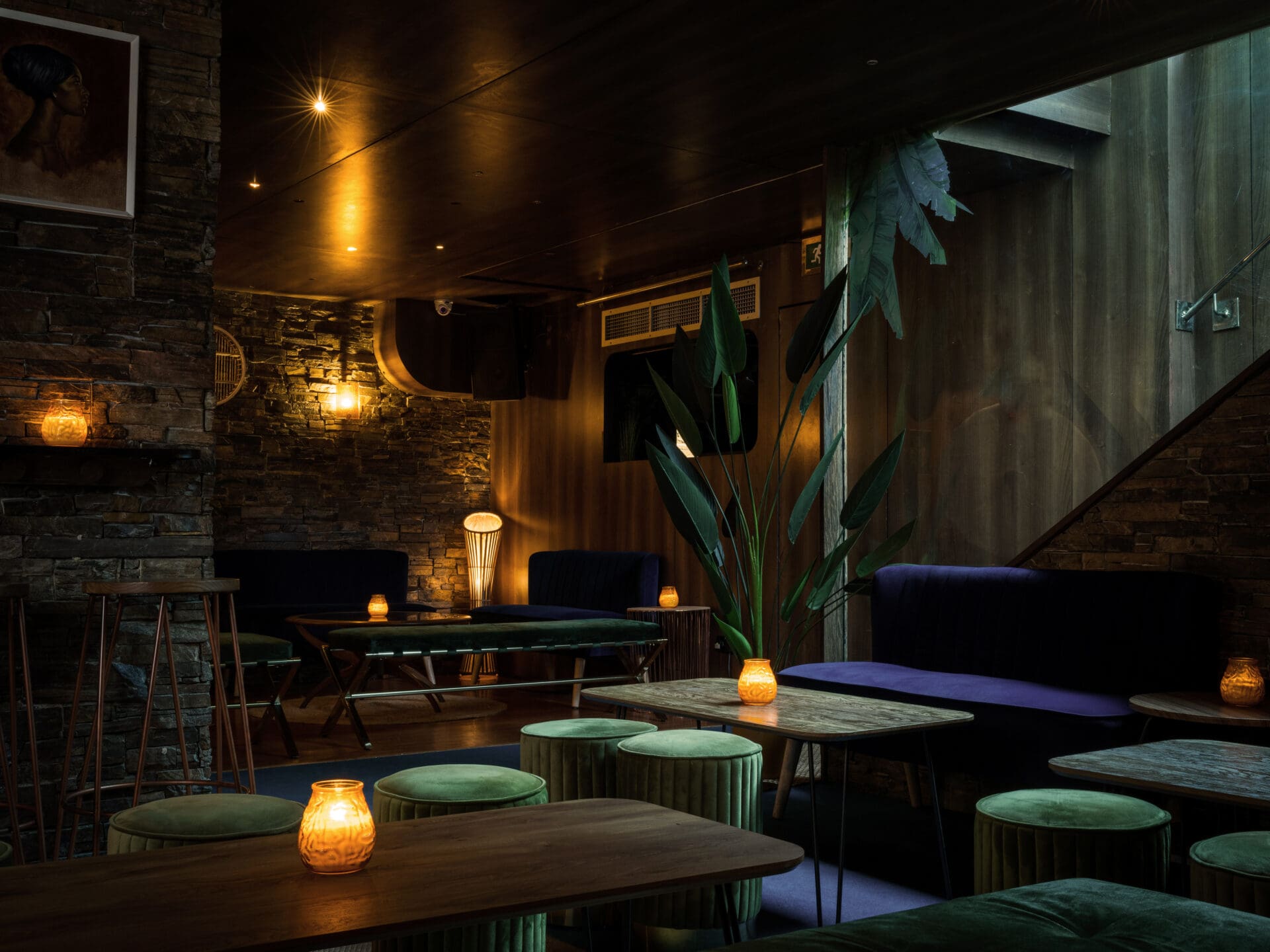Best cocktail bars London | Greenery and green velvet stools alongside low tables crowned by candles at Trailer Happiness