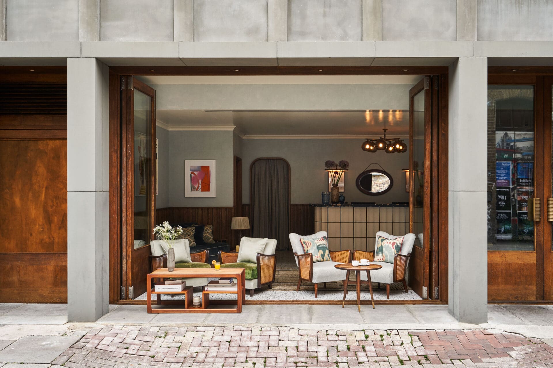 Best hotels in Shoreditch, Dalston and Hackney | A view of Redchurch Townhouse from the outside. Doors are open completely, and armchairs and tables sit on the threshold.