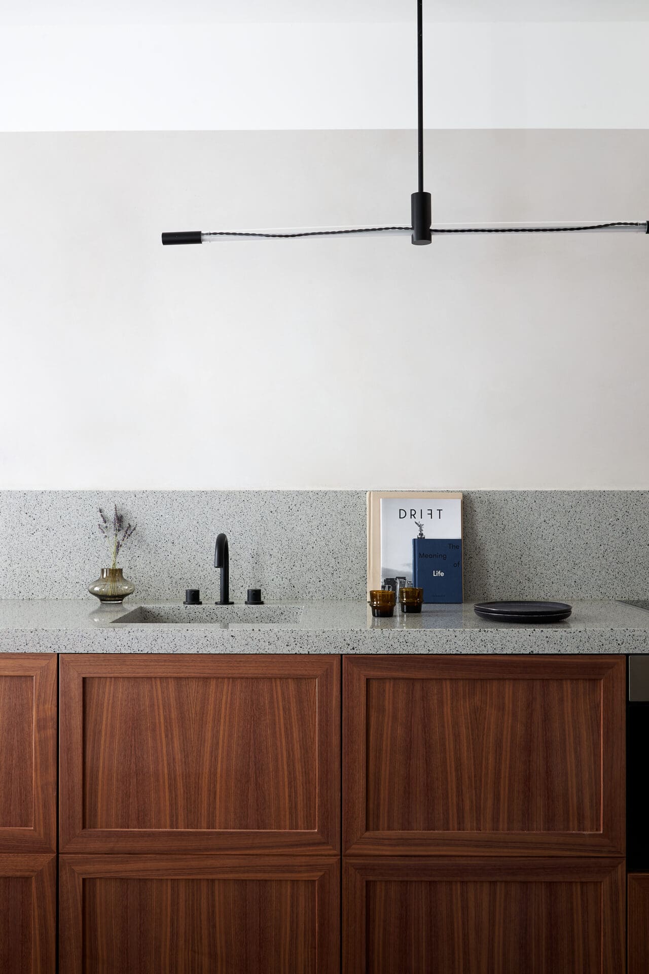 Best hotels in Shoreditch, Dalston and Hackney | A view of a kitchenette in one of the rooms at Kingsland Locke in Dalston, London. A sculptural light hangs from the ceiling, and a small sink in a terrazzo counter can be seen, with a copy of Drift magazine perched against the wall.