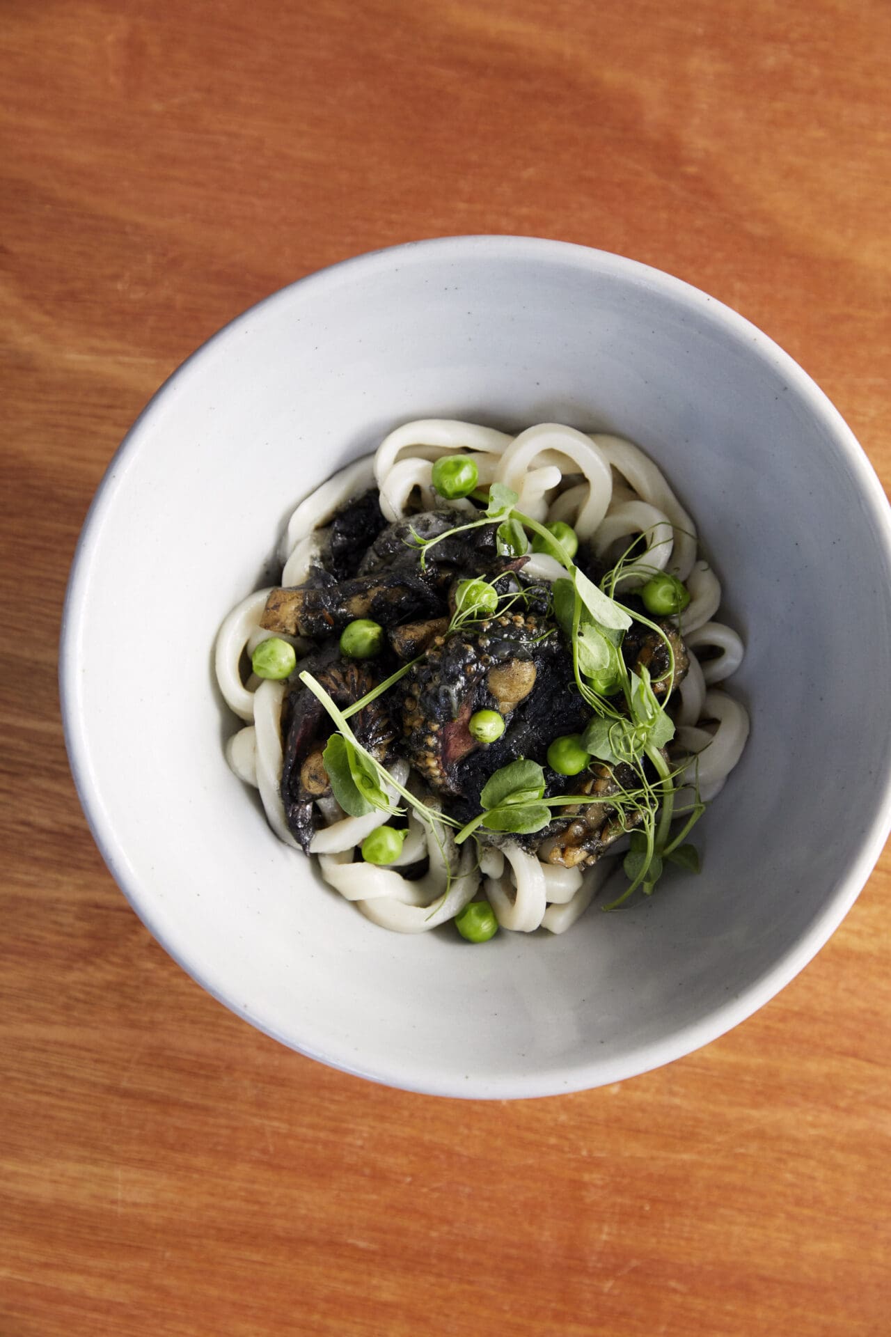 Best restaurants in Hackney | A bowl of cuttlefish and sweet pea udon on a wooden table top at Koya Ko in Hackney