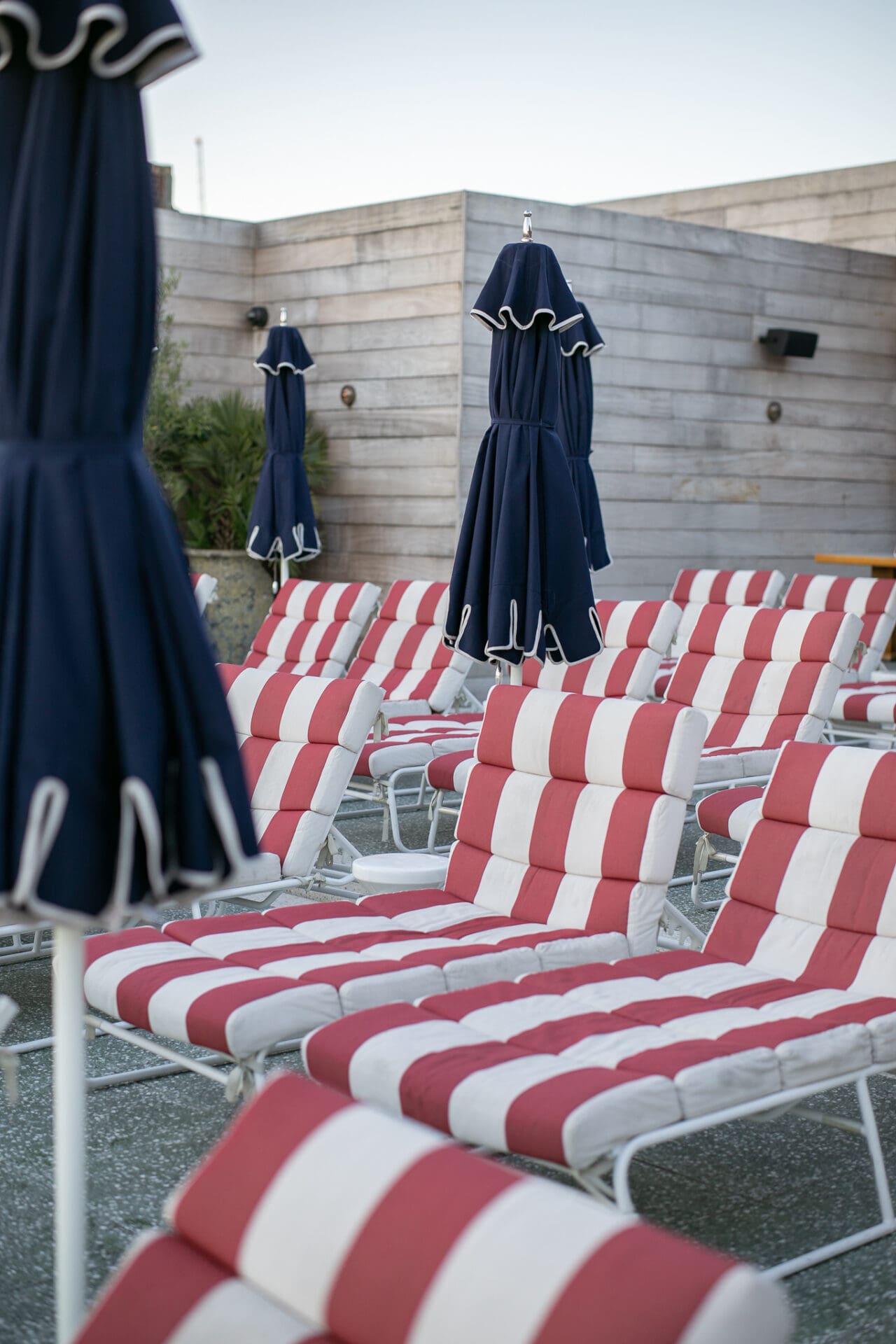 Best hotels in Shoreditch, Dalston and Hackney | Red and white striped deck chairs with closed blue parasols on the rooftop of Shoreditch House