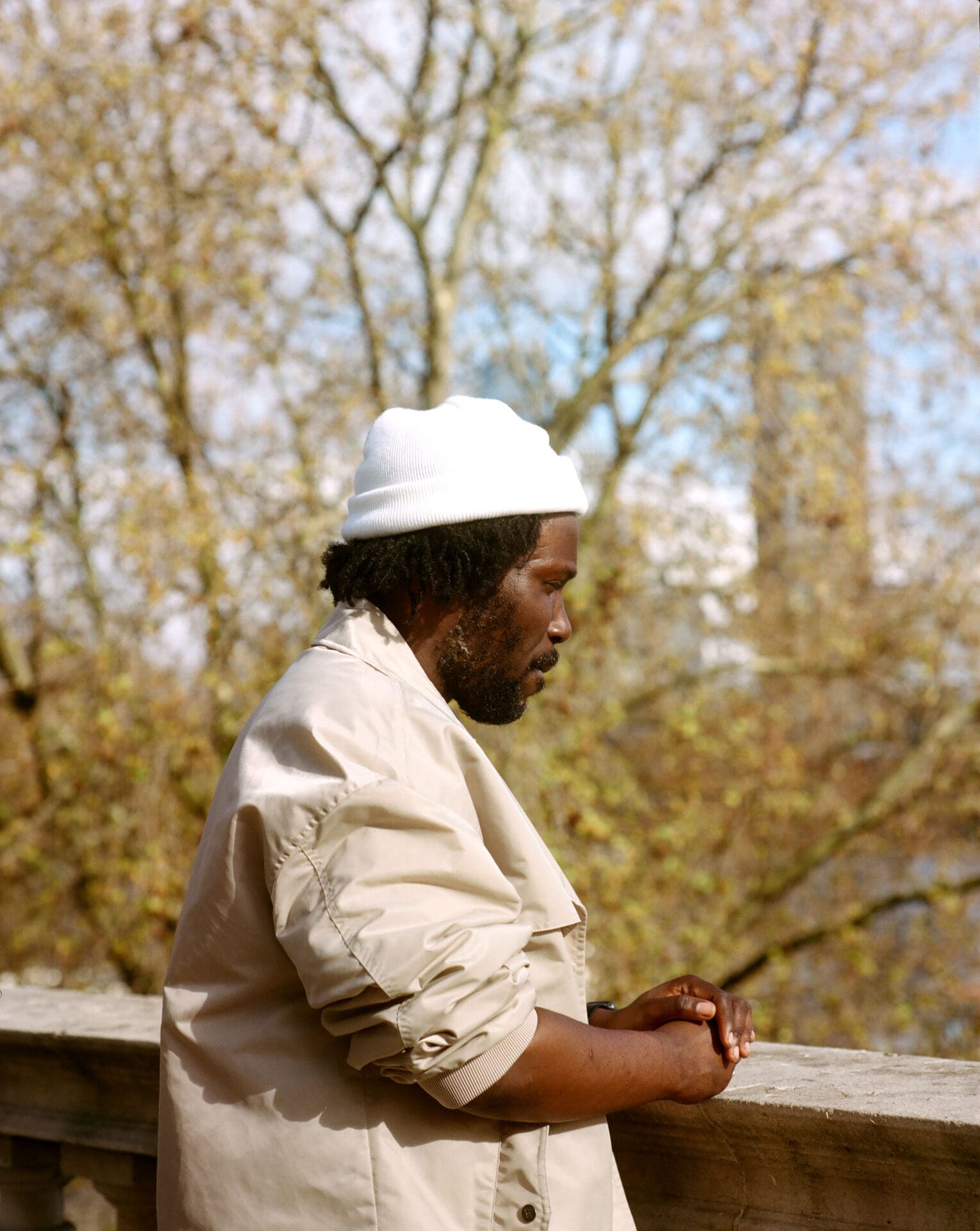 Akwasi Brenya-Mensa clasping his hands and looking out at the River Thames on the terrace at Somerset House