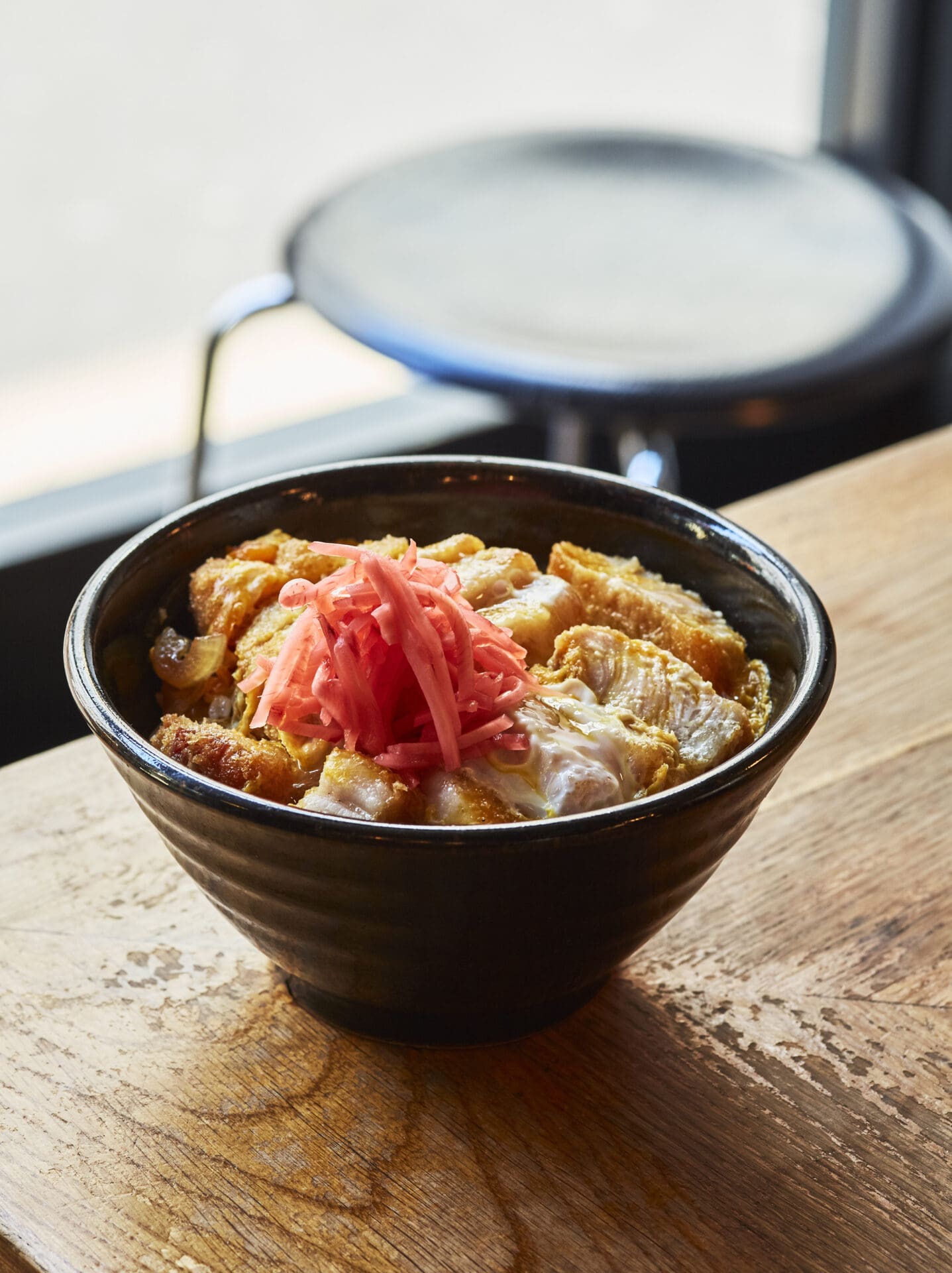 Shuko Oda | Koya Ko's katsu udon, in a brown ceramic bowl and topped with bright-pink pickles