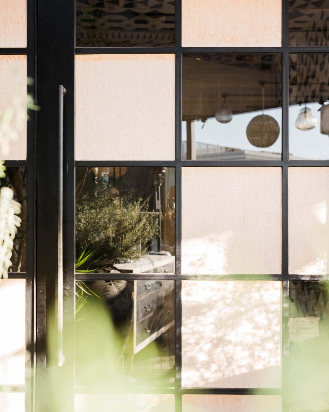 The interiors of Margot in Culver City seen through a door reflection