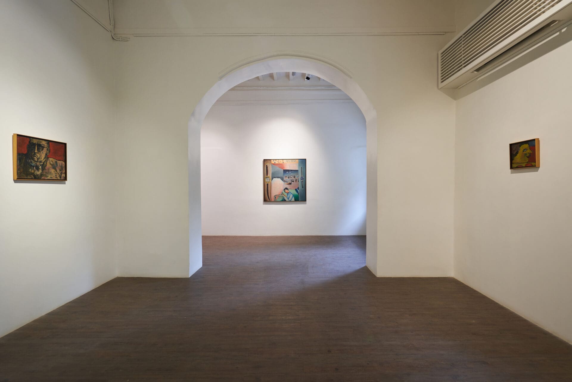Best art galleries in Mumbai | A view inside Akara Art, with small paintings hung on the white walls, with one visible through a wide archway.