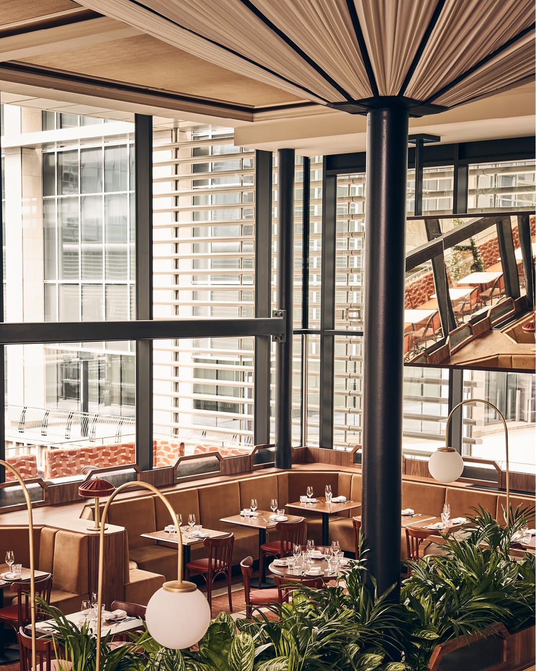 A warm palette of brass mirrors and leather banquettes at Marceline in Canary Wharf