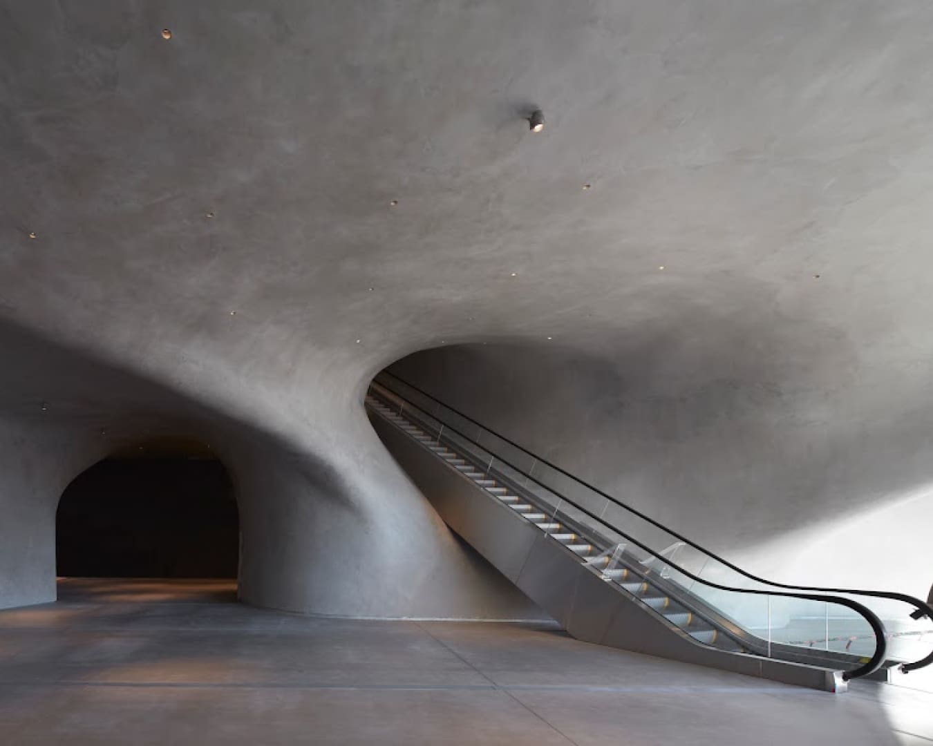 The imposing interiors of The Broad, with a curved concrete structure and an escalator in view