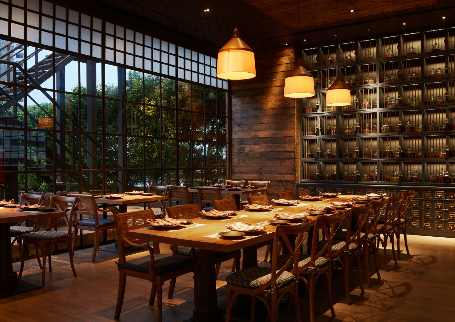 Bangkok's Thai-Indian community | A sleek dining room at Charcoal restaurant in Bangkok, with dark wood details and a long communal dining table