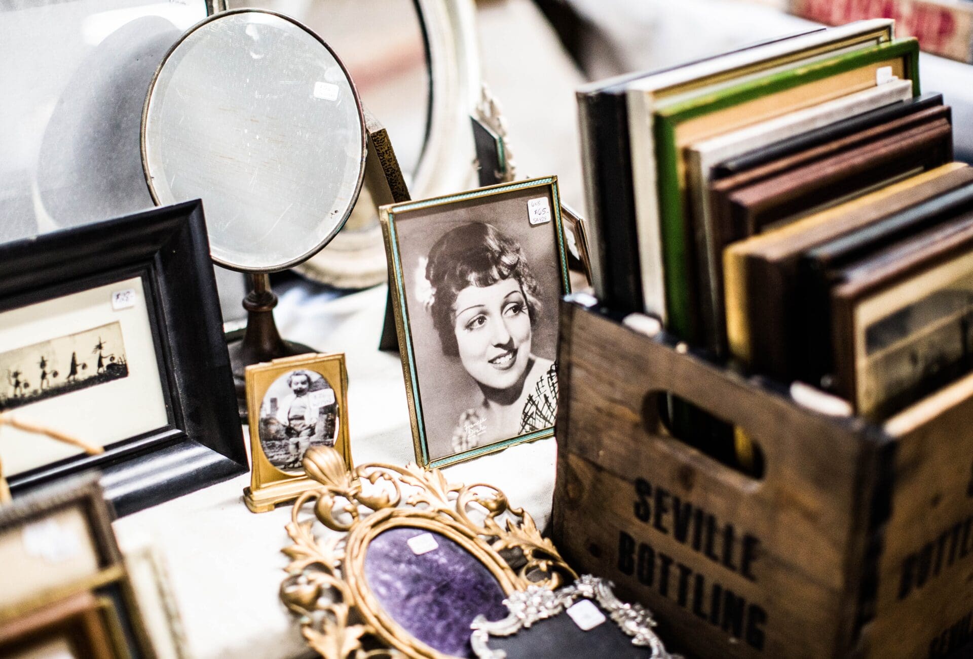 Is the hidden gem dead? A black and while photo and a cardboard box filled with photo frames at a flea market stall