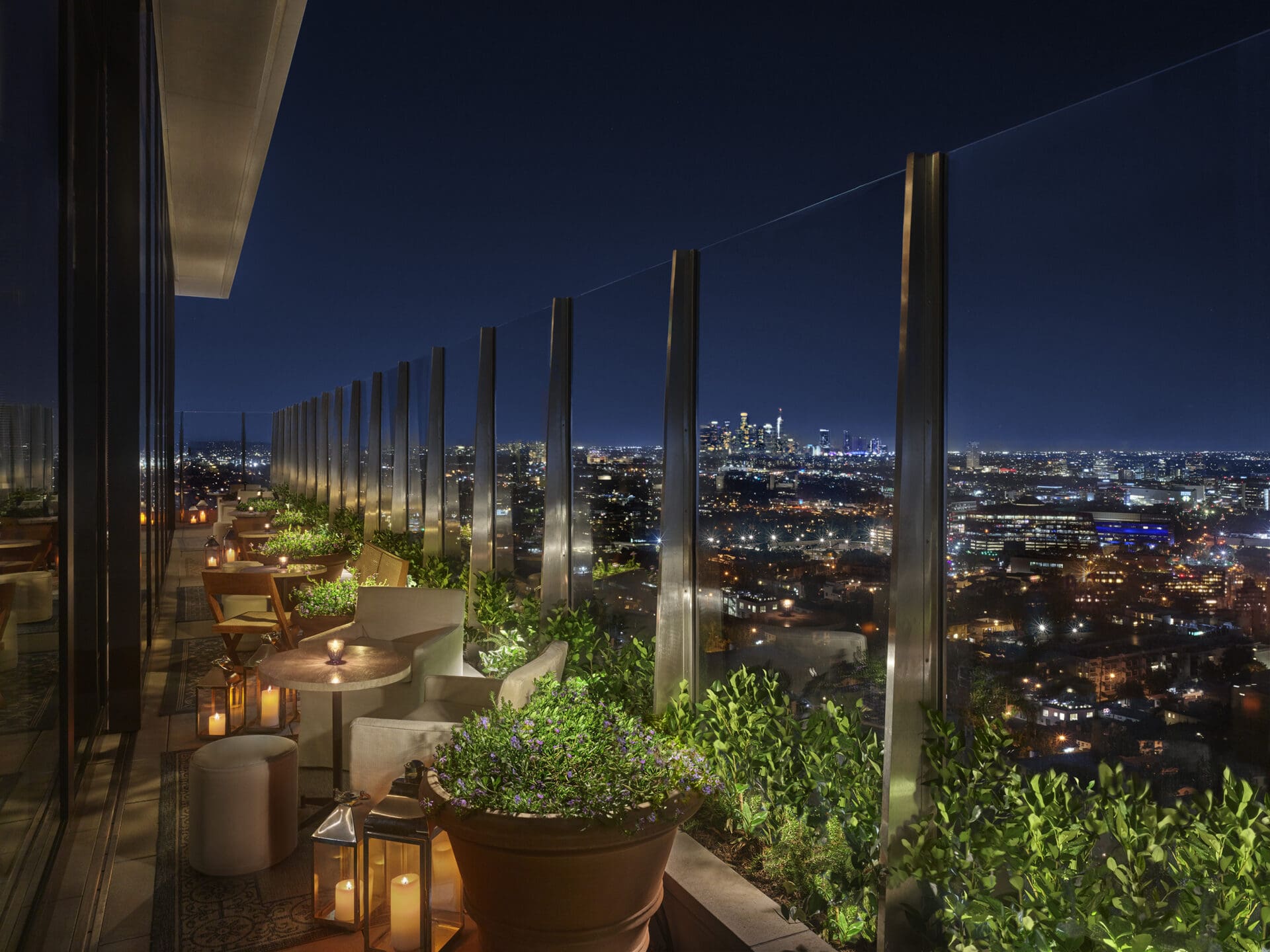 Best rooftop bars LA | Upstairs bar at the West Hollywood EDITION at night, with intimate table topped with glowing tea lights, and views over LA