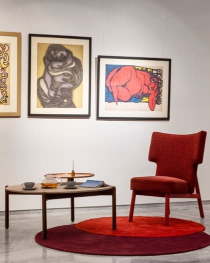 Best co-working spaces in Mumbai | A circular red carpet and a red armchair in front of a white wall adorned with artwork at Kathiwada City House