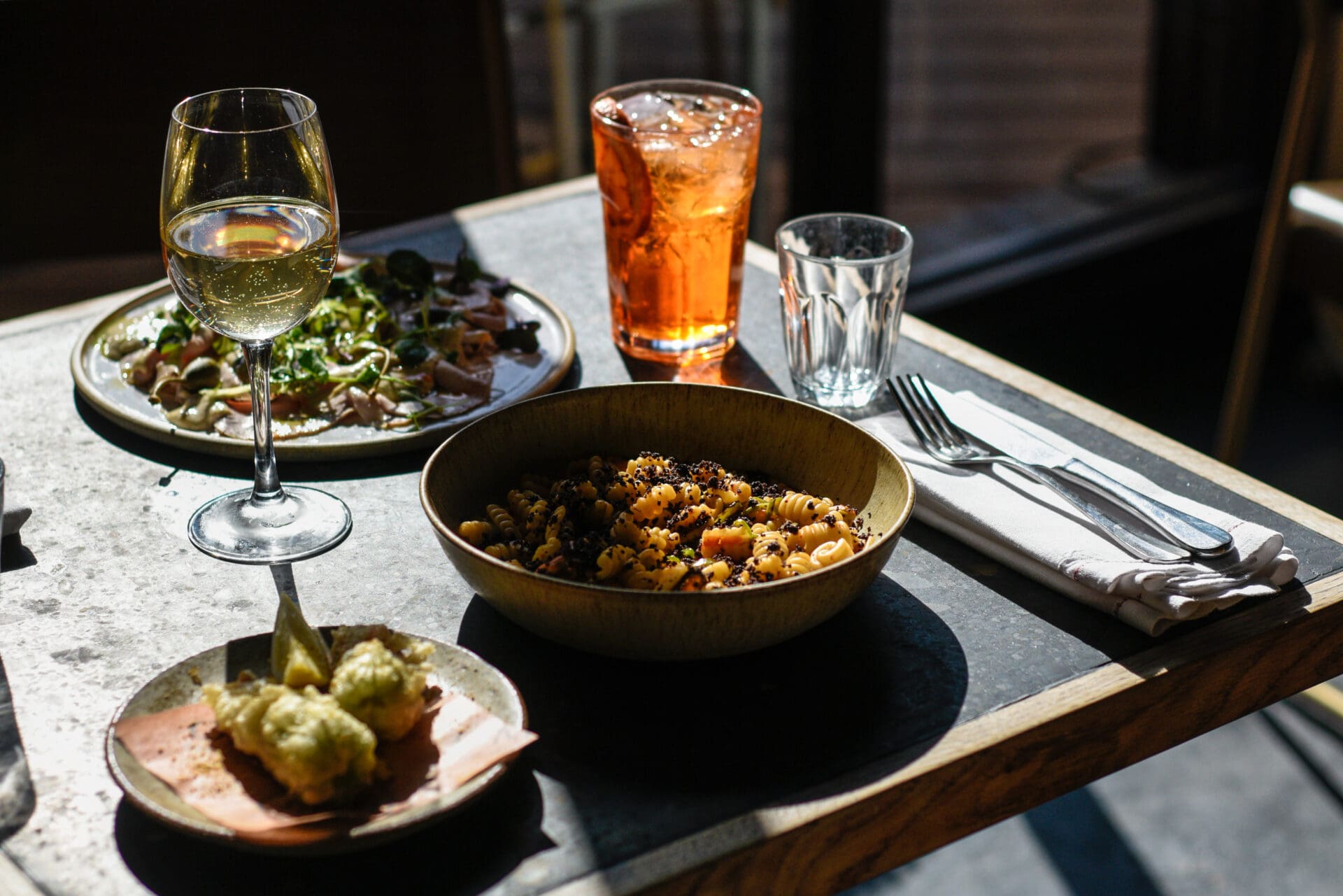 Outdoor restaurants in London | A pasta dish and a spritz served on a sunny table at Ombra