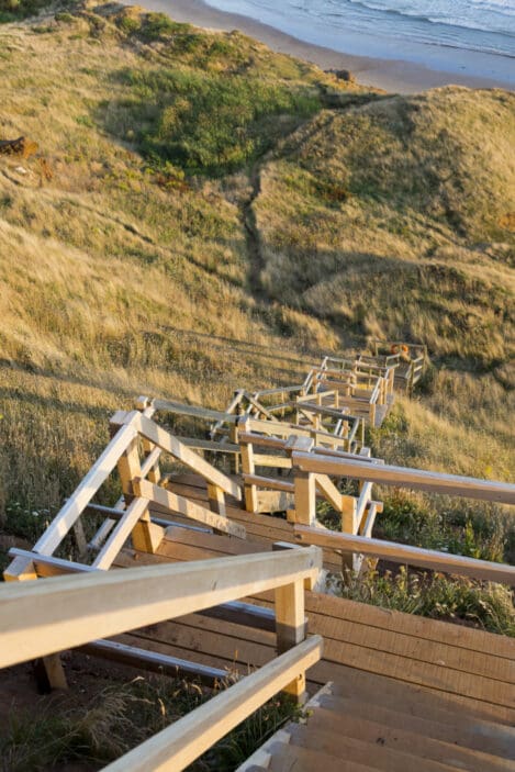 Isle of Wight | An angular wooden staircase descending down a grassy hill towards a beach