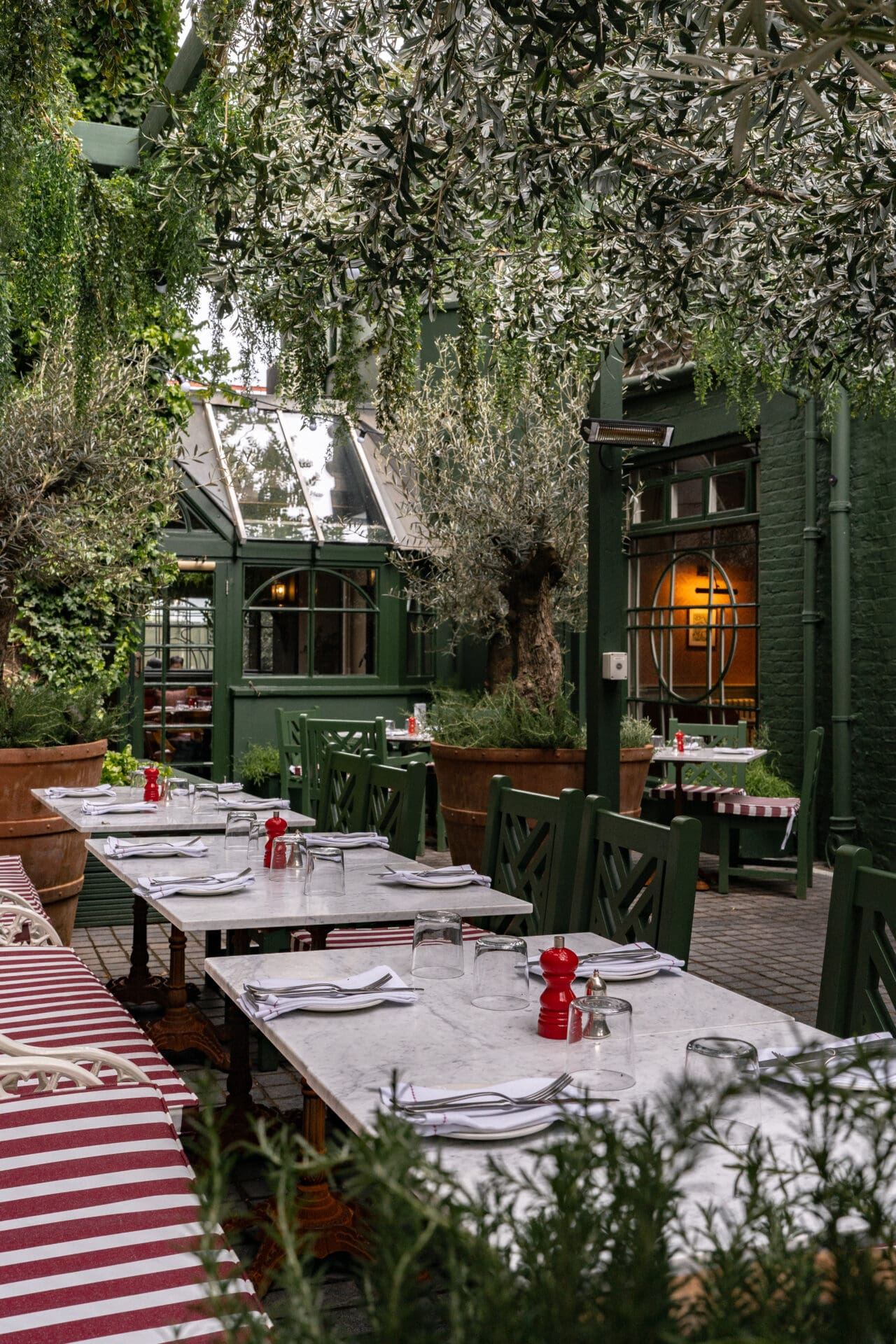 Best restaurants with outdoor seating in London | Princess Royal's terrace with marble tables, red-and-white striped cushions, shaded by greenery