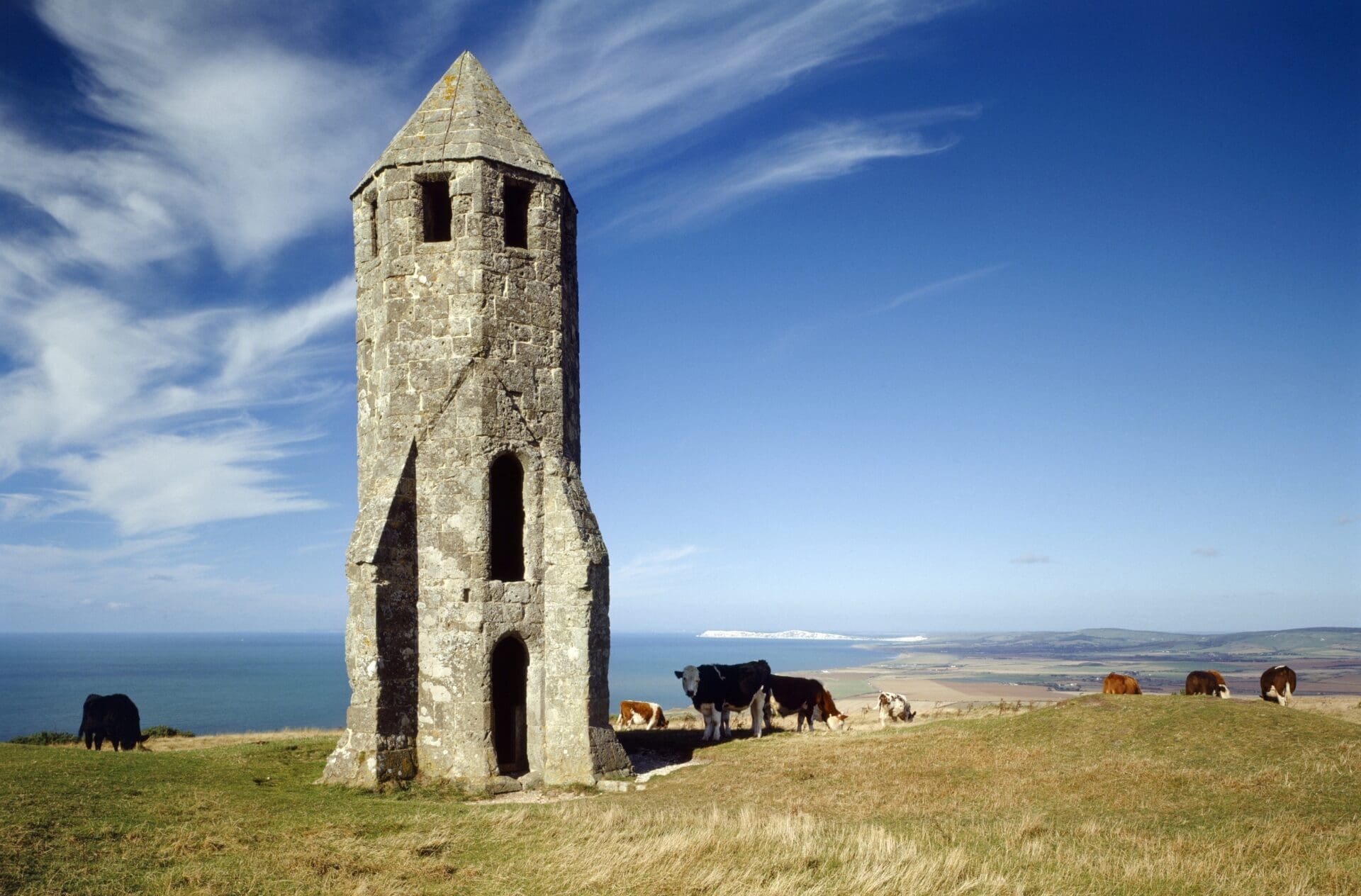 Isle of Wight | A stone tower, St Catherine's Oratory, with a pointed roof, on a grassy knoll with views over the coastline