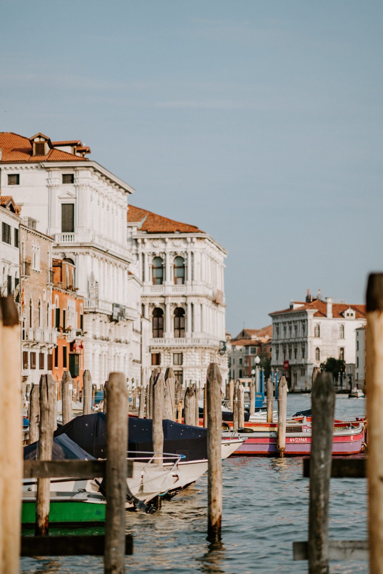 Running in Venice | A view over the harbour at Venice, with wooden poles sticking out of the water in front of beautiful white renaissance-style buildings