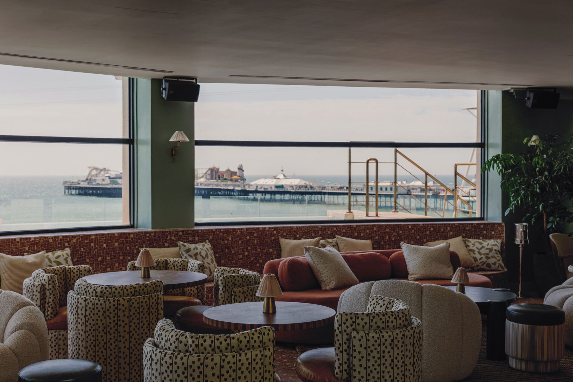 Best bars in Brighton | Brighton Beach House's bar, with 70s interiors in shades of orange and green and a view looking out to the pier