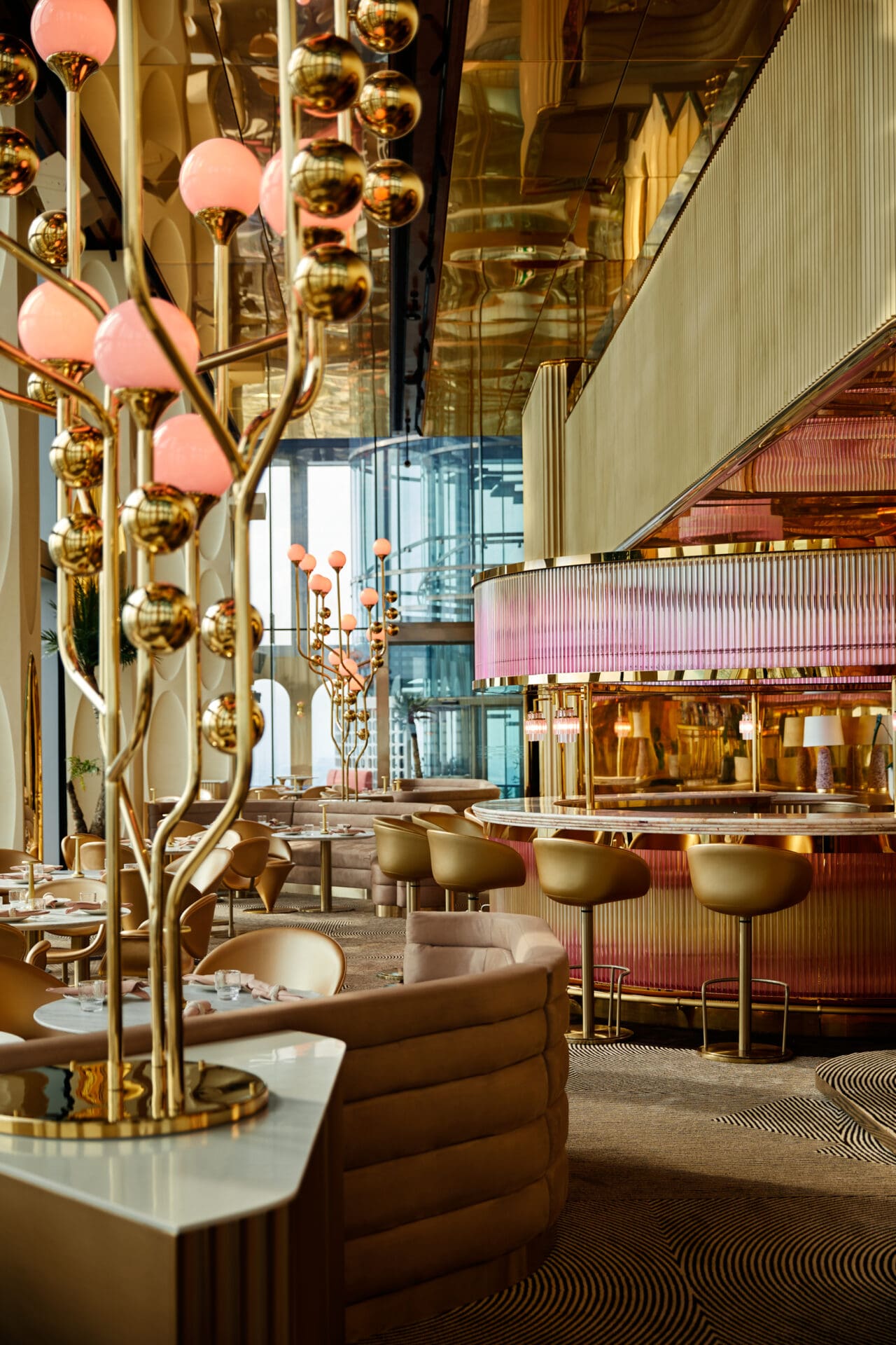 The Standard Bangkok Mahanakhon hotel opening | Ojo restuarant's gold interiors, with counter stools at the bar and orange-hued lamps