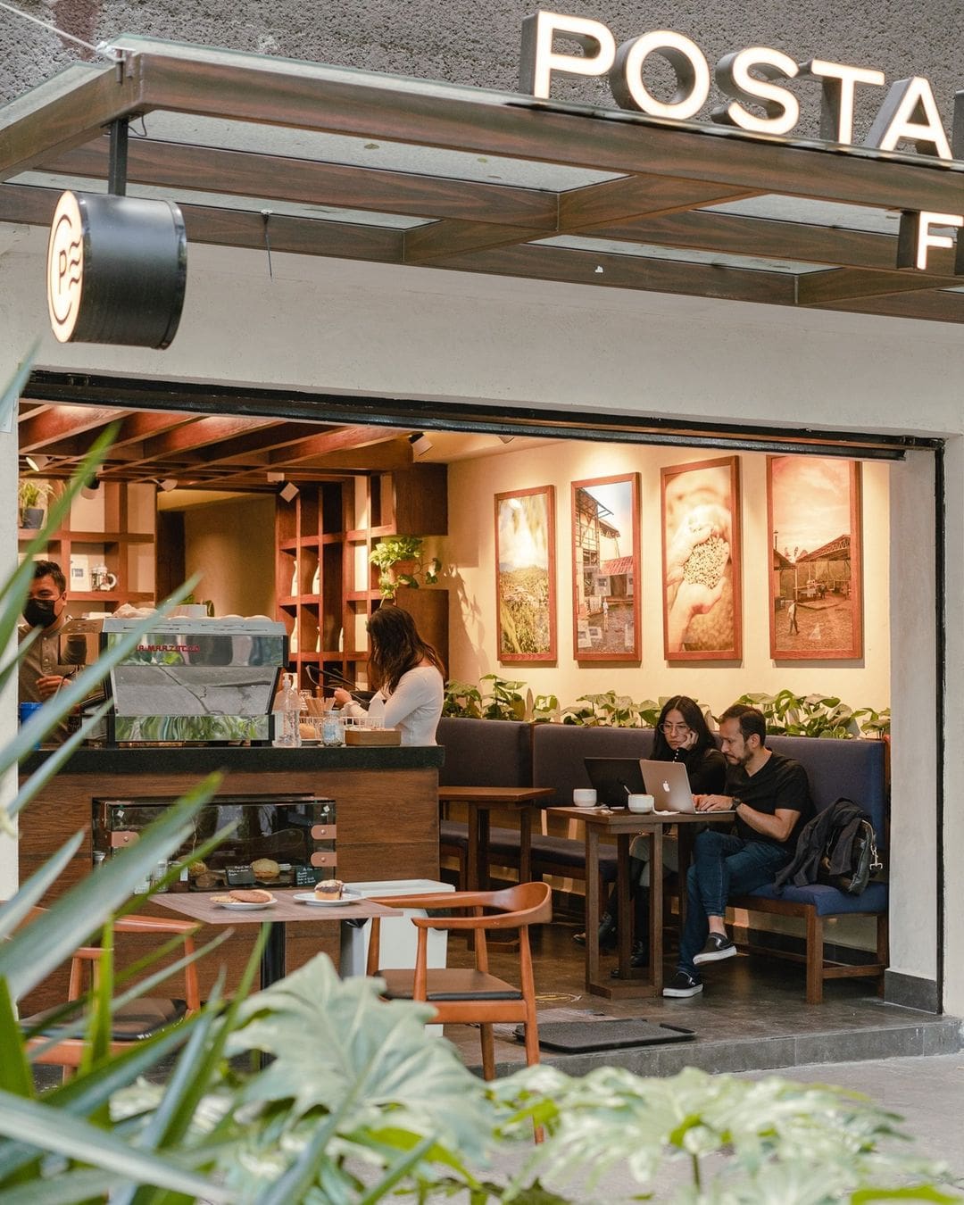 A view into Postales, where you can see the counter area and two people sat on a banquette at a table