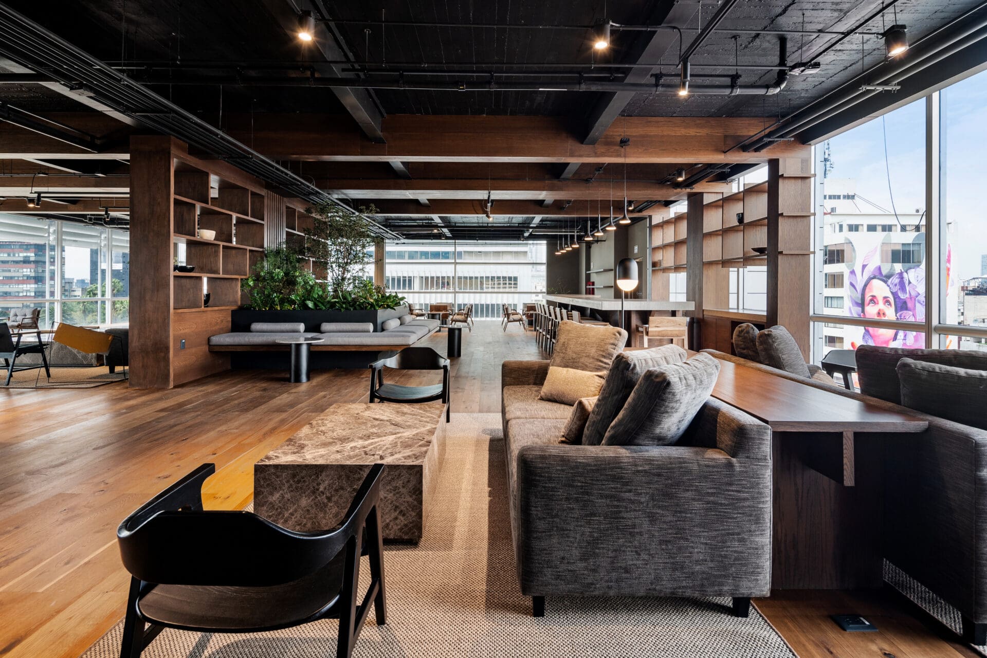 The best places to co-work in Mexico City | sleek sofas and chairs in a spacious open-plan room with wooden floors and floor-to-ceiling windows