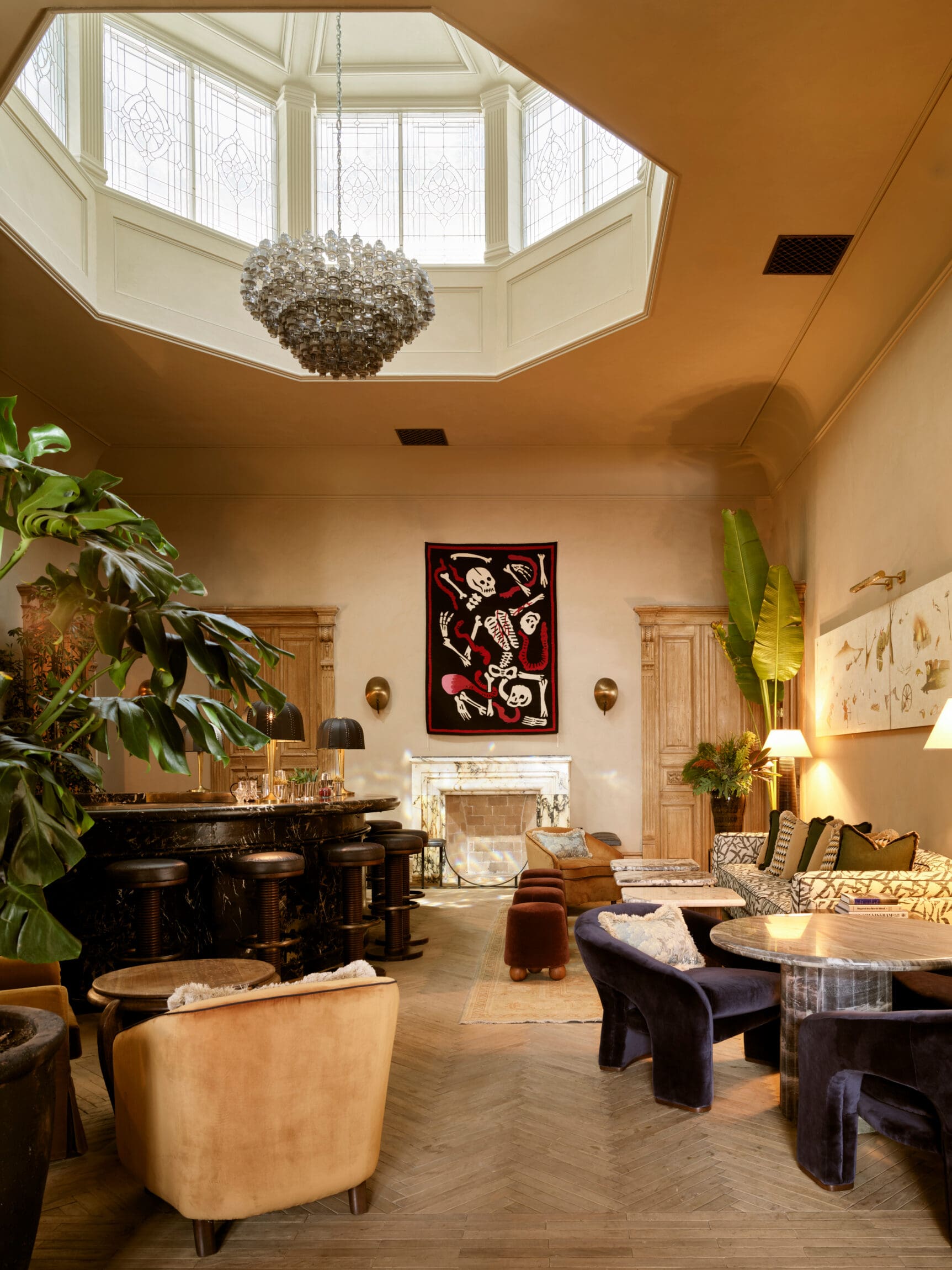 Soho House Mexico City | a lounge area with velvet seating and striking skeleton artwork