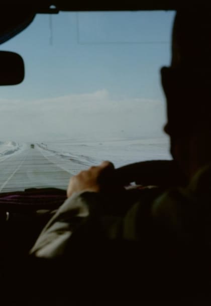 Coco Capitan | A view through a car window over the driver's shoulder on a snow-dusted road in Siberoa
