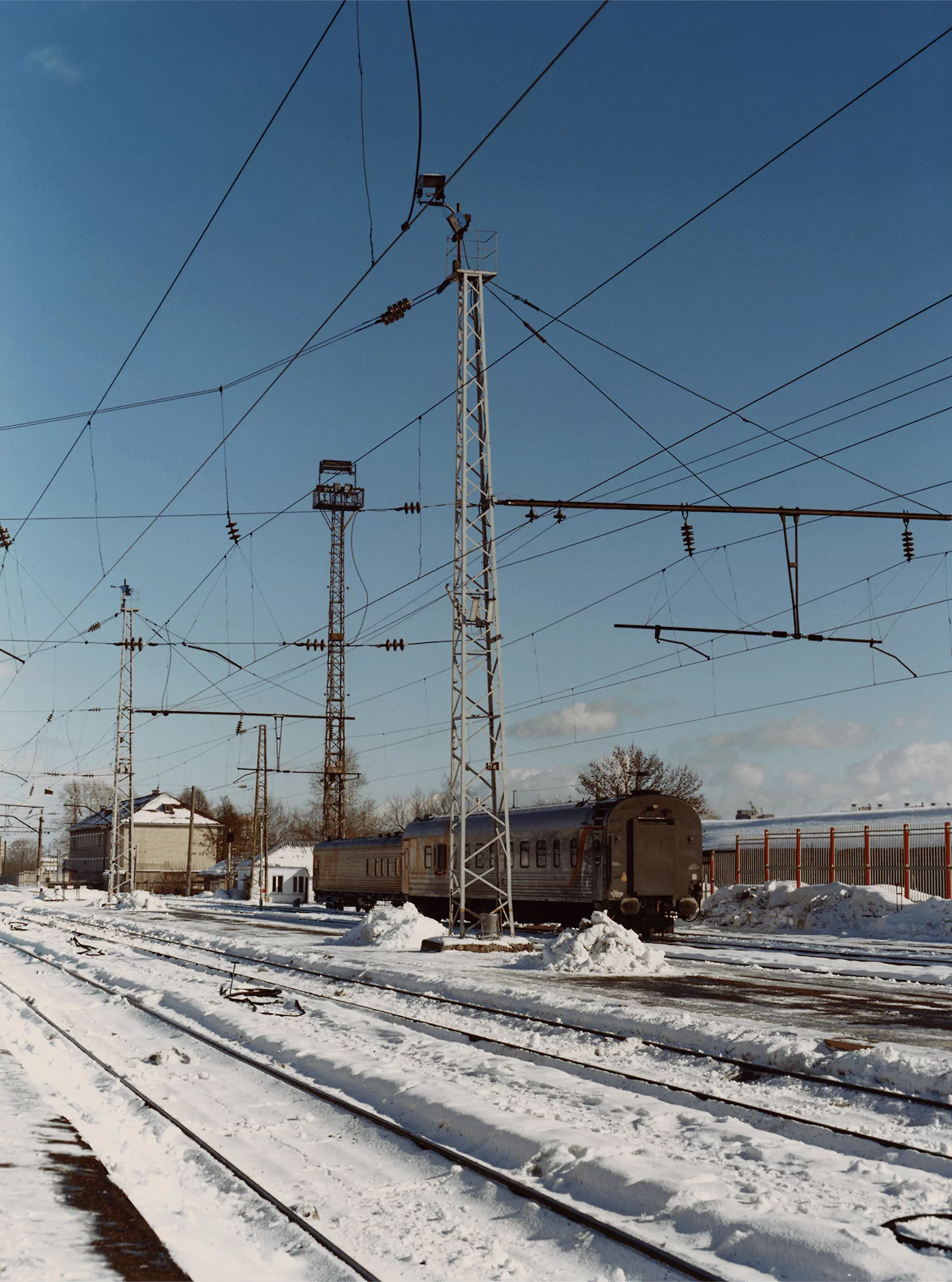 Coco Capitan, Transsiberian | Snow-covered railway tracks and pylons against a blue sky