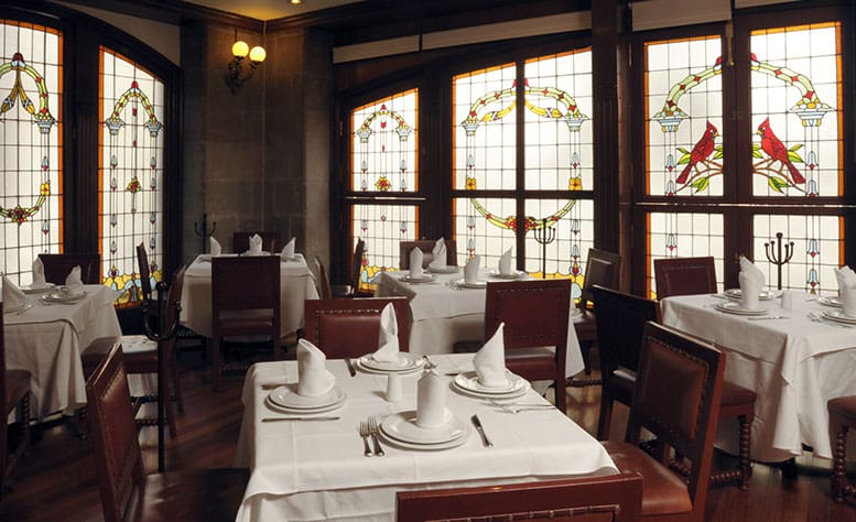 The best restaurants in Mexico City | an interior view of El Cardenal, with dark wood and white tablecoths
