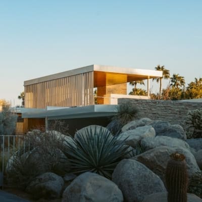 What to do in Palm Springs, California | A midcentury modern home lit in the golden evening sun against a cloudless blue sky