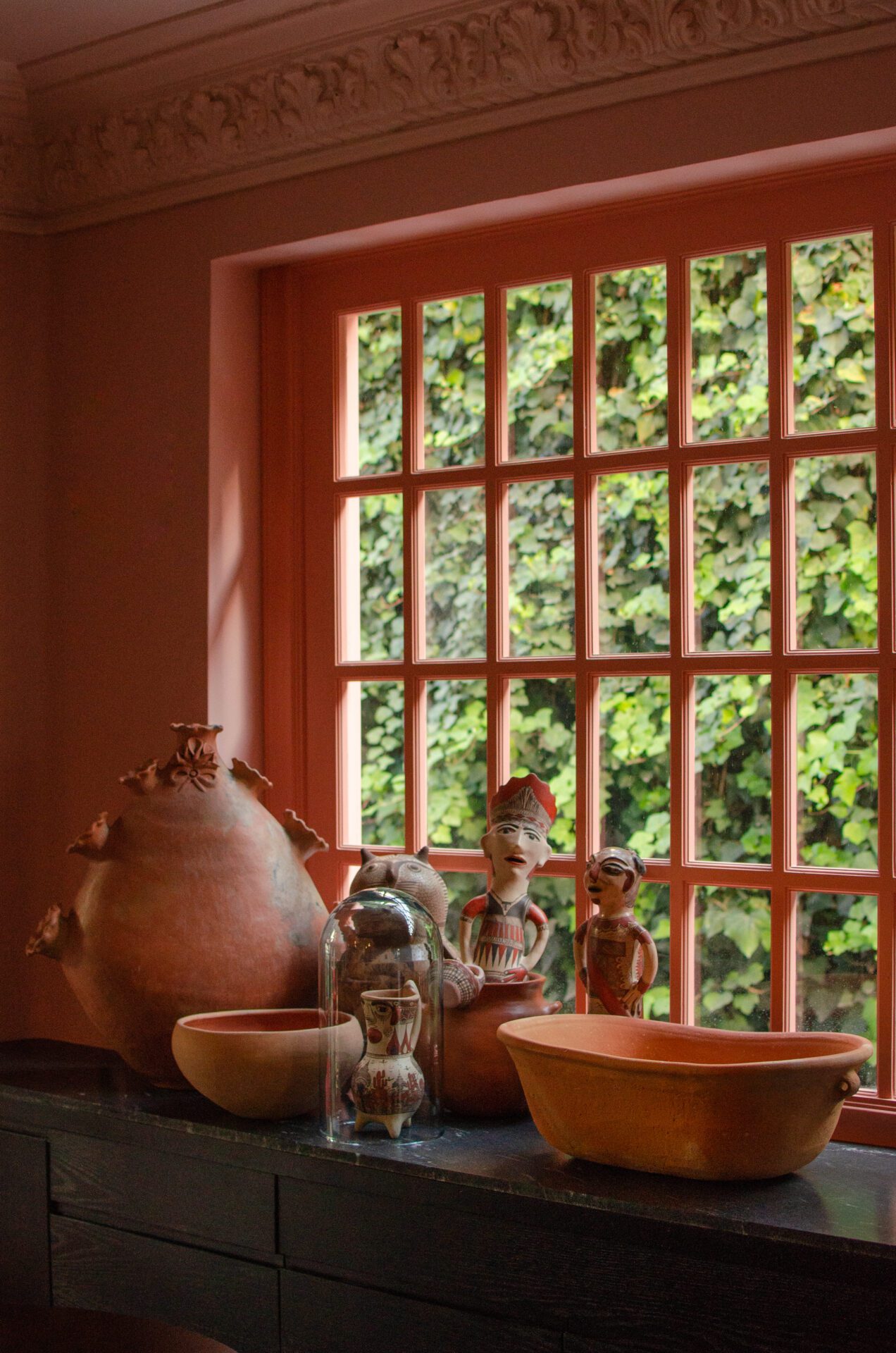 The best hotels in Mexico City | A collection of ceramic pots and craft objects on a windowsill in Ignacia Guest House