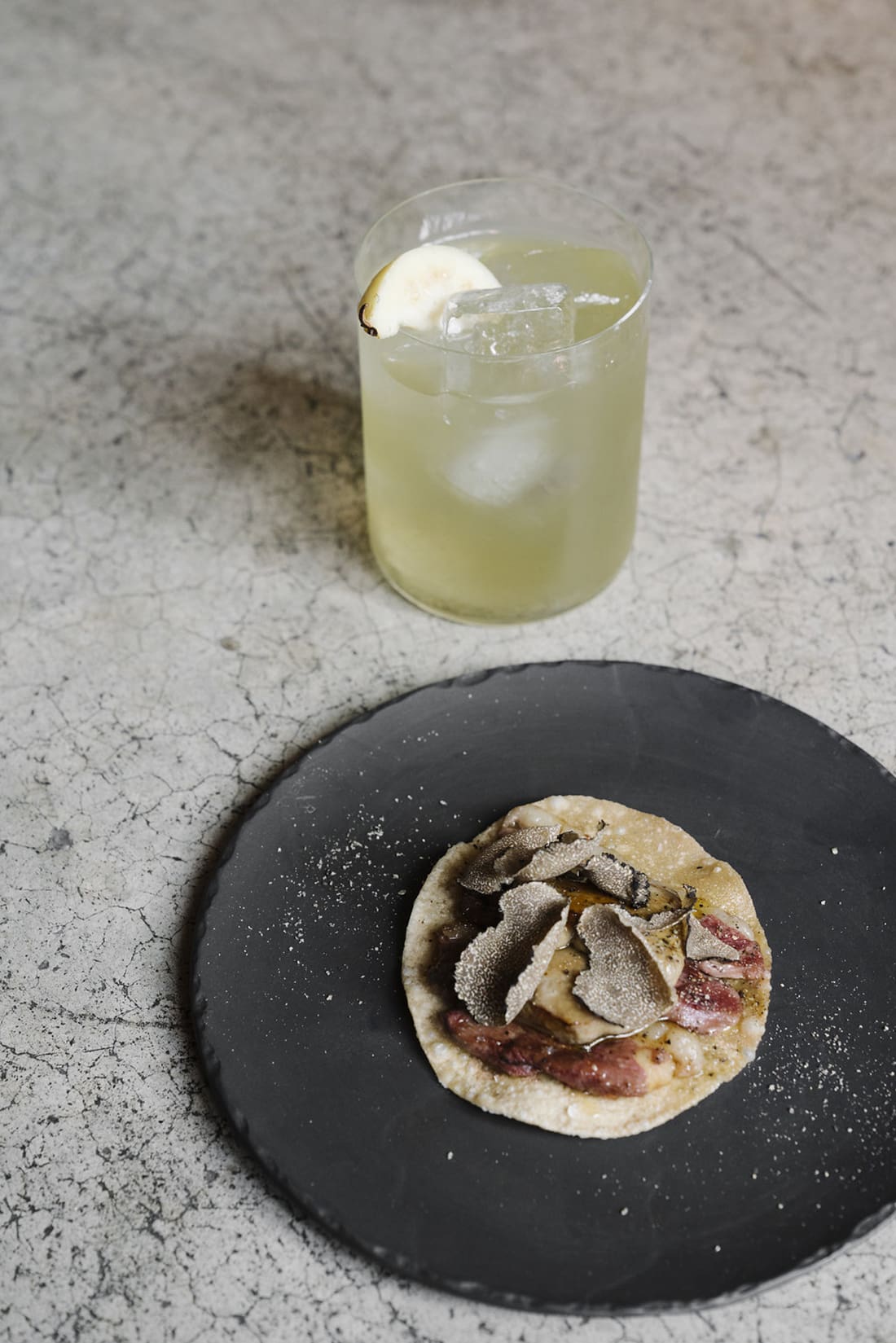 The best bars in Mexico City | A cocktail and small taco on a black plate at Le Tachinomi Desu