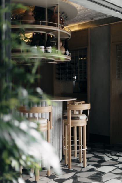 The best restaurants in Mexico City | A view of the bar at Malix, with a high wooden stool facing a curved counter, and a black-and-white checked floor