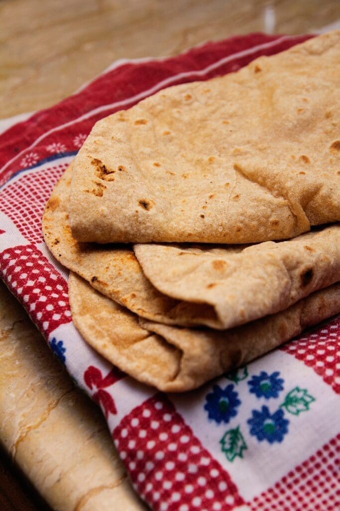 The best street food in Mumbai | A pile of folded roti on a patterned tea cloth.