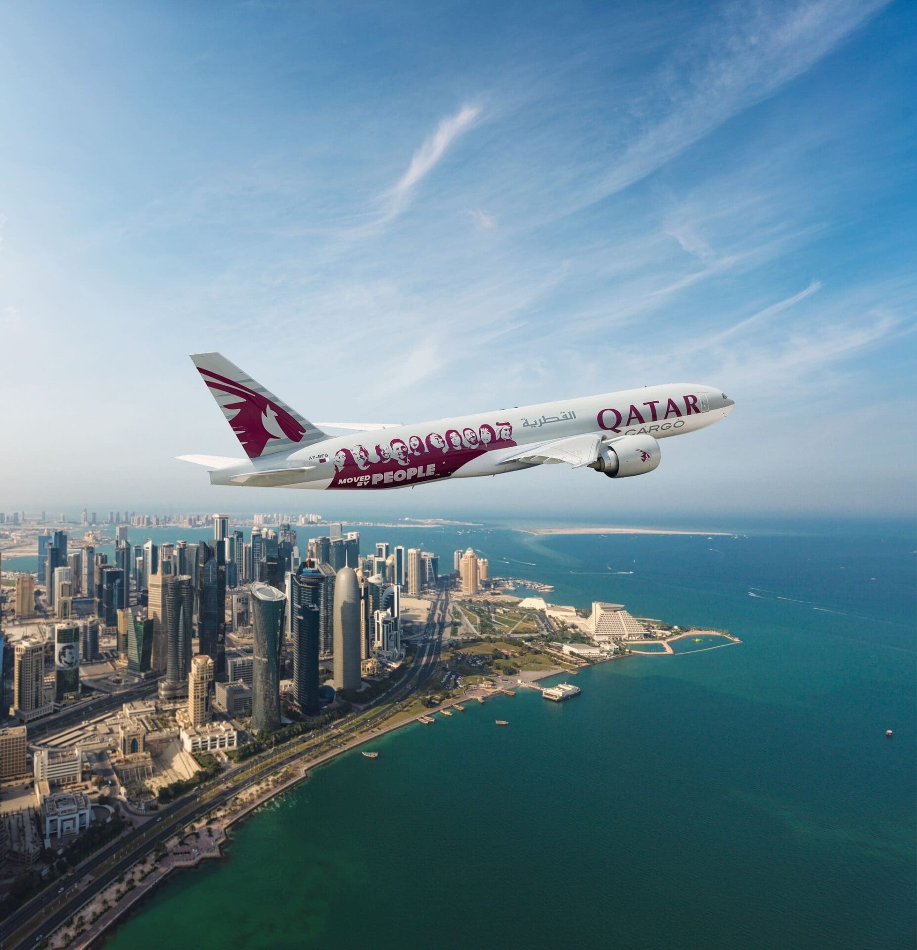 A Qatar Airways plane flying over the sea and Middle Eastern city