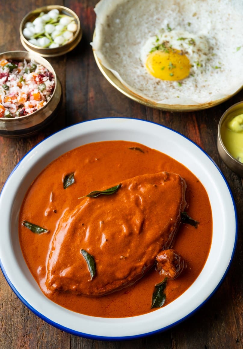 The best restaurants in Bandra, Mumbai | A red tamarind fish curry in a bowl on a wooden tabletop