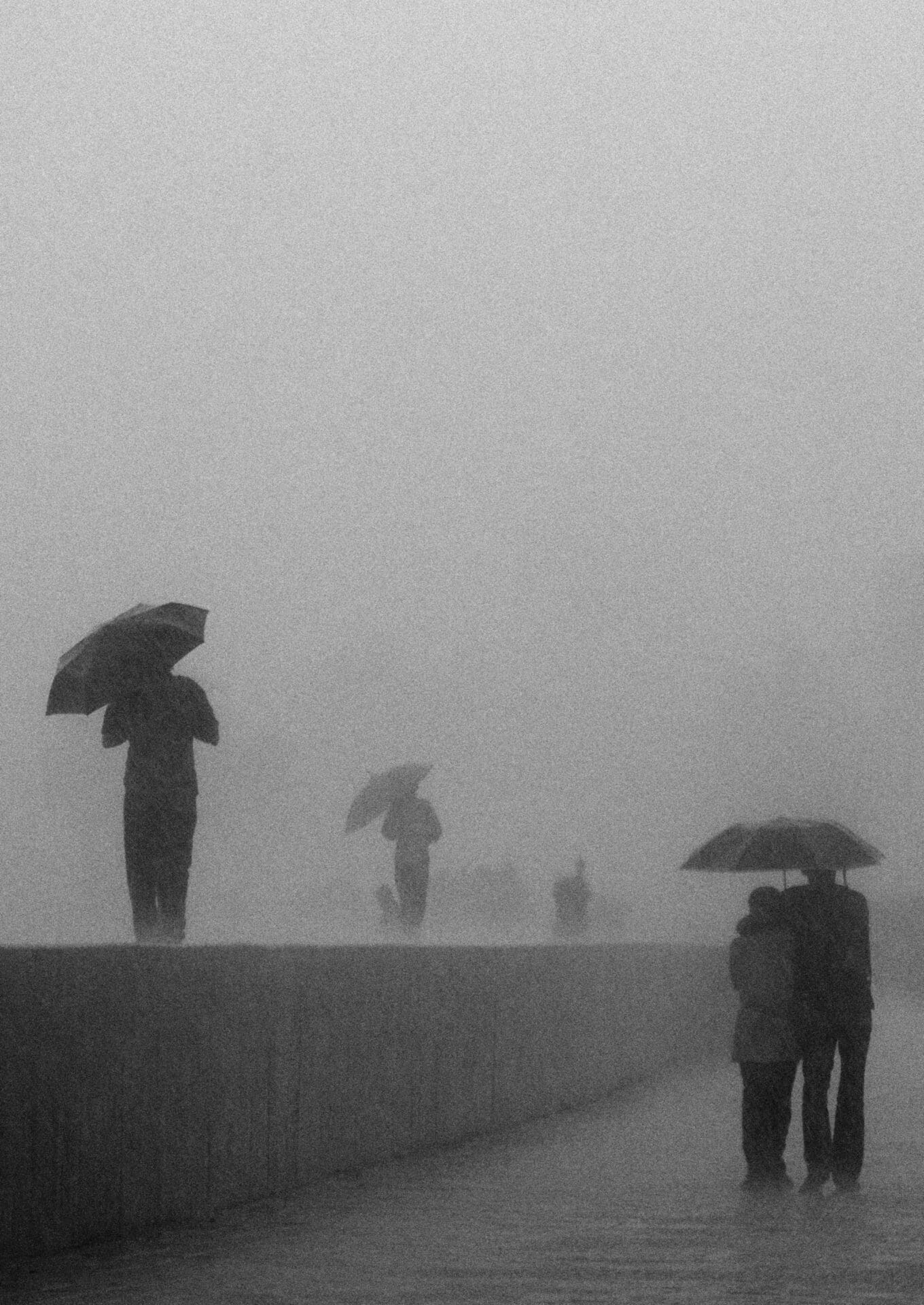 Photographer Sunhil Sippy on Mumbai | Figures holding umbrellas walk through the mist